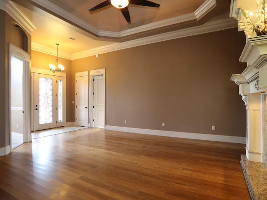 SOLID BRICK HOME 45k in upgrades in ceilings and fireplace from standard home built in this subdivision-- Must see-- 2454 square feet of custom touches from floor to ceiling! 12 foot trey ceilings in the Living room and dining room, complete with triple crown molding! Tile throughout with the exception of hardwood floors in the living room. Beautifully crafted ornate fireplace in the living room is a fantastic focal point! Kitchen has custom cabinetry , granite counter-tops and has new stainless steel appliances installed. Master suite has a gorgeous coffered ceiling that is absolutely stunning. Master bath includes glass shower, whirlpool tub, dual vanity, under-counter lighting and large walk-in closet. The 8-foot doors  Playground and recreation area in the subdivision is perfect for your active lifestyle!