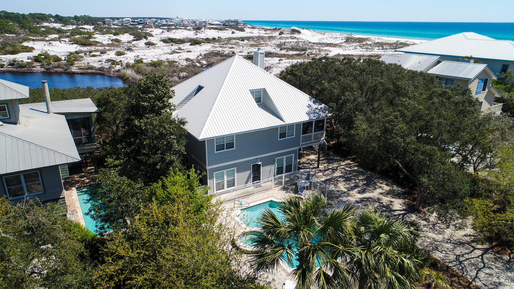 Don't miss this opportunity. No other beach development, in the area, has the unique advantage of being isolated and protected from adjacent development. Gulf Trace sits like an island on the edge of the coast, buffered on all sides by the natural world - the Gulf of Mexico and Grayton Dunes State Park to the east, north, and west. Upon entering, through the screened porch on the second floor, this newly renovated home (brand new flooring, paint and furnishings) you're overlooking the Gulf and protected coastal dune lakes of the State Park. The second floor features panoramic views from the sunroom, kitchen and dining room. Main level also features two bedrooms and a laundry room. The entire top floor is your master suite with private balcony. Bottom floor is