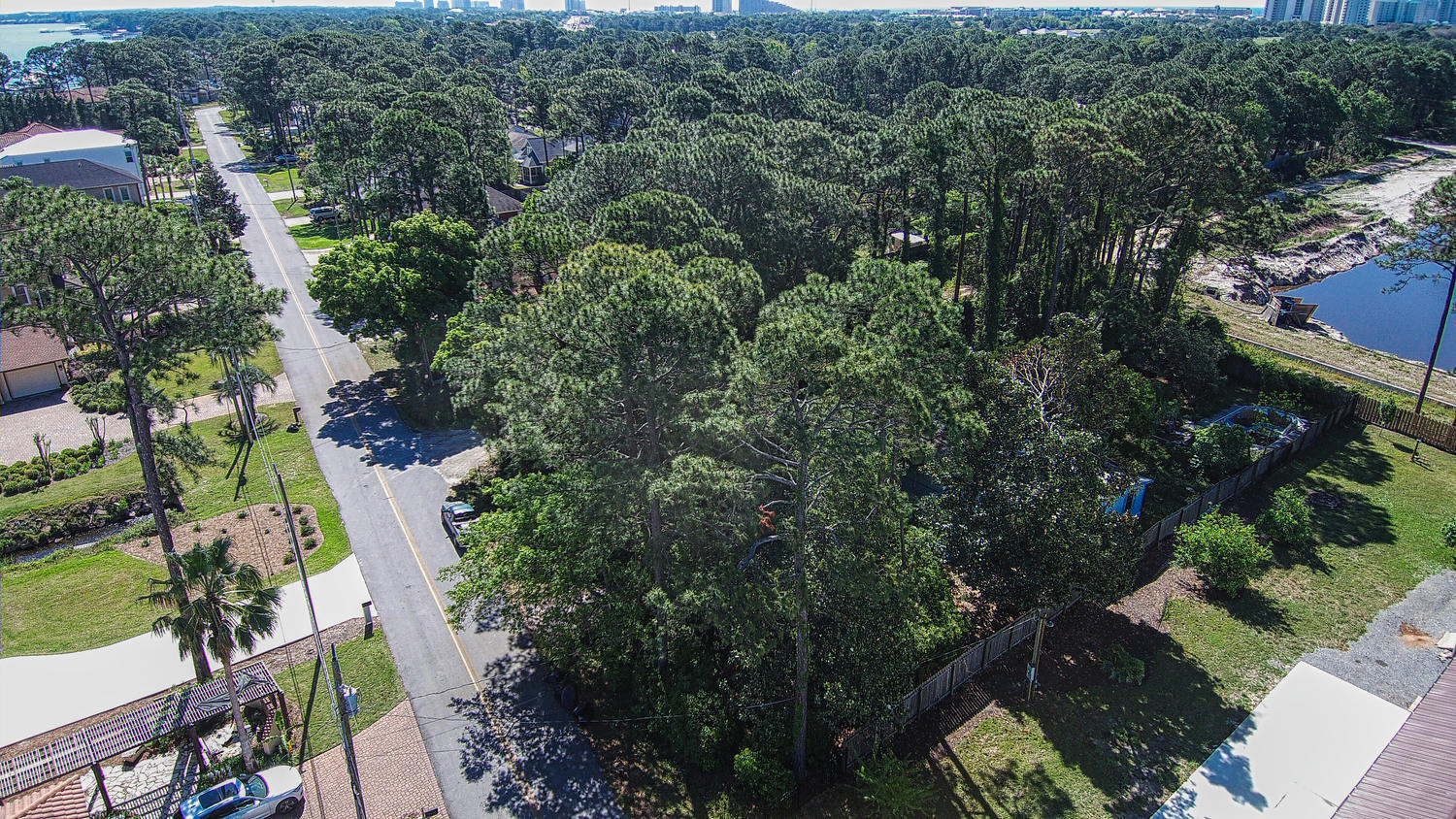 AS IS - Great Location! Just minutes from shopping, resorts, beaches.....lot has bay views, quiet neighborhood on dead end. Build a dream home on this 1/4 acre 65X200 lot or park your RV. NO HOA. The property has existing structures but sale of this property is not contingent on condition of structures only lot value and available utilities paid. Beautiful trees for privacy. Tear down and start fresh with beautiful lot and location!