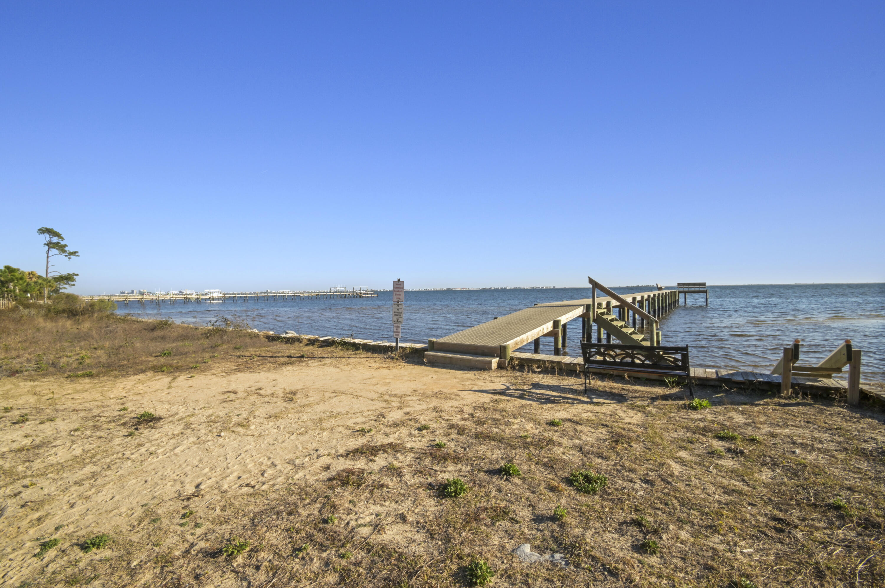 This spacious home has been completely updated over the past few years with modern touches throughout! The WATERFRONT neighborhood is perfect for families and has low HOA fees, a PRIVATE BEACH, a large COMMUNITY PIER on the Santa Rosa Sound, sidewalks, and a community POOL - the best parts of Florida living! Stepping into the home you're immediately greeted by the open-concept central living space complete with a tall, vaulted ceiling. This huge space is perfect for entertaining guests and even includes a wood burning fireplace - perfect for our chilly NW Florida winters! The kitchen is the crown jewel of this home. Designed for the family chef, the kitchen is equipped with stainless steel appliances, an island, a pantry, seemingly unlimited counter space, and tons of storage. Just off of the kitchen is a dining area with an abundance of natural light. This home comes with 3 guest bedrooms, all of which are large enough to fit queen beds. The master bedroom is huge and can easily accommodate a California King bed with an abundance of space to spare. The walk-in closet is massive with more space than you would ever need! The ensuite master bath is a show-stopper. With a jetted tub, a separate large shower, a modern granite dual-vanity, and a towel closet, there was no expense spared when updating the bathroom! The screened patio off the sliding glass door includes an outdoor bar and provides the perfect space to enjoy the outdoors without the bugs! The privacy-fenced backyard is big enough for any project you may have in mind and includes 4 new sump pumps keeping the yard nice and dry no matter the weather. This home only has ONE NEIGHBOR ensuring peace and quiet. The garage comes with enough space for 2 cars plus storage, and the driveway can easily accommodate an additional 4 vehicles! This spacious, updated Navarre home offers waterfront community living at an affordable price-tag! Request a showing today and make this house your home!