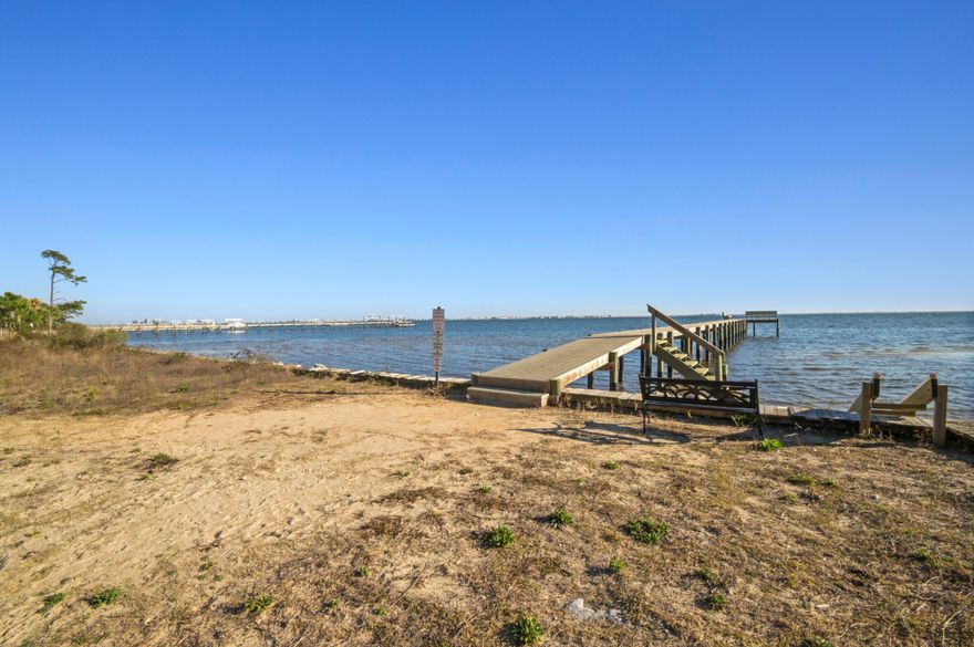 This spacious home has been completely updated over the past few years with modern touches throughout! The WATERFRONT neighborhood is perfect for families and has low HOA fees, a PRIVATE BEACH, a large COMMUNITY PIER on the Santa Rosa Sound, sidewalks, and a community POOL - the best parts of Florida living! Stepping into the home you're immediately greeted by the open-concept central living space complete with a tall, vaulted ceiling. This huge space is perfect for entertaining guests and even includes a wood burning fireplace - perfect for our chilly NW Florida winters! The kitchen is the crown jewel of this home. Designed for the family chef, the kitchen is equipped with stainless steel appliances, an island, a pantry, seemingly unlimited counter space, and tons of storage. Just off of the kitchen is a dining area with an abundance of natural light. This home comes with 3 guest bedrooms, all of which are large enough to fit queen beds. The master bedroom is huge and can easily accommodate a California King bed with an abundance of space to spare. The walk-in closet is massive with more space than you would ever need! The ensuite master bath is a show-stopper. With a jetted tub, a separate large shower, a modern granite dual-vanity, and a towel closet, there was no expense spared when updating the bathroom! The screened patio off the sliding glass door includes an outdoor bar and provides the perfect space to enjoy the outdoors without the bugs! The privacy-fenced backyard is big enough for any project you may have in mind and includes 4 new sump pumps keeping the yard nice and dry no matter the weather. This home only has ONE NEIGHBOR ensuring peace and quiet. The garage comes with enough space for 2 cars plus storage, and the driveway can easily accommodate an additional 4 vehicles! This spacious, updated Navarre home offers waterfront community living at an affordable price-tag! Request a showing today and make this house your home!
