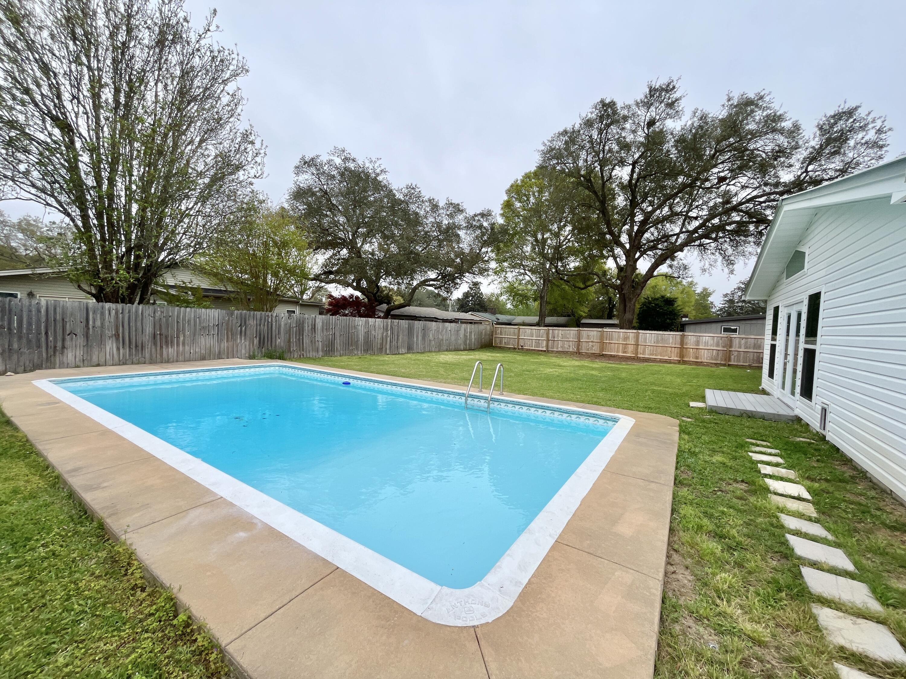 POOL home in Kenwood neighborhood. Seller has updated so much of this adorable home. Updated tile flooring throughout. Gorgeous kitchen with all new cabinets, quartz countertops, appliances, recessed lighting, and features a pantry with glass door for added storage Bathrooms updated w/toilets, vanity in hall bath & walk-in MBA shower. A 2018 remodel added a bonus room filled with windows. A combo full accessible bath and laundry room are located off the bonus room. The expansive backyard has a sparkling pool and 2 storage sheds. Endless other updates include replacing the metal roof 2018, tankless gas water heater 2018,, new gas furnace, HVAC & ducts 2017, impact windows 2018, new interior & exterior doors, impact garage door, attic insulation, gutters, sprinkler system 2017, lawn pump well pipe/valve 2022, pool pump & new filter sand 2022, fence and gates, changed electric service to the house, new interior paint 2024. Solar panels added 2020. Seller will pay these off before closing. Power bills averaging $65/month. They really do reduce your energy costs!