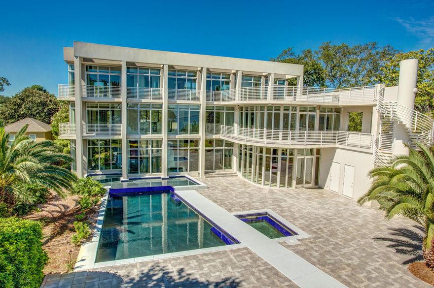 Stylishly artistic and contemporary, this light-filled residence in Destin's exclusive Cobb's Point offers a fabulous waterfront lifestyle with incredible modern conveniences. It combines many desirable elements of high end Miami-style real estate with the best of the Emerald Coast lifestyle in one special property.The glass entrance opens into an incredible 3-story high living space with a stunning wall of windows facing Choctawhatchee Bay. The main spaces are expertly designed to flow with ease from the indoor living area with large bar, to the outdoor patio, formal dining room, fabulous gourmet kitchen, and entertainment/media room. From the floating staircase to the artistic light fixtures, gorgeous kitchen cabinetry, and mosaic tile powder room wall, each design element offer
