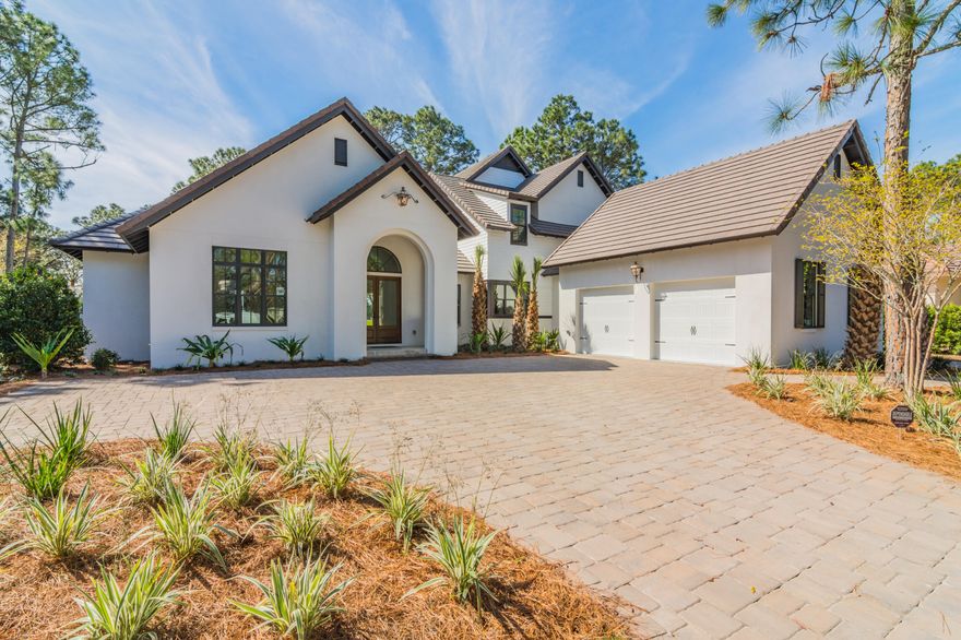 Almost new and immaculate home in the coveted Island Green neighborhood of the Sandestin Golf and Beach Resort, this stunning home features 3,782 square feet of thoughtfully designed spaces with four bedrooms plus a bunk room, four full bathrooms, and two half bathrooms. Custom built in 2018 by Turner Legacy Homes, warm toned hardwood floors contrast with crisp white walls with high ceilings and beautiful millwork. The spacious living area is highlighted by a striking coffered ceiling and sliding doors that fully open to an expansive covered porch with outdoor kitchen and gas fireplace overlooking the private pool and picturesque greens of the 2nd hole and 3rd tee box of the Raven Golf Course. A pool bath and storage room provide added convenience for an afternoon soaking up the sun at
