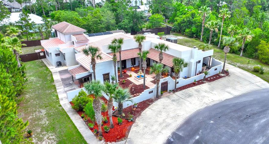Nestled in the highly sought-after Mack Bayou area of Santa Rosa Beach, this exquisite Spanish Hacienda-inspired estate offers a rare blend of architectural charm, expansive living, and refined indoor-outdoor entertaining - all just minutes from 30A and GrandBoulevard  with their vibrant mix of upscale dining, shopping, and coastal lifestyle experiences. Situated on a private road, this thoughtfully designed residence welcomes you through a gated courtyard adorned with a striking double-tiered fountain, setting the tone for the serene elegance found throughout. The home's flowing layout includes a spacious mainresidence and a private guest wing, ideal for multi-generational living or hosting in style. The main house boasts a grand living room anchored by a fireplace and custom built-ins, seamlessly connecting to the formal dining area and an oversized chef's kitchen complete with island, breakfast nook, pass-through windows to the lanai, and abundant storage. Soaring glass doors open onto a luxurious screened lanai featuring a pool, spa, and multiple patio spaces perfect for alfresco gatherings.
The expansive master suite is a private retreat with a fireplace, two separate access points to the lanai, a spa-inspired bath with soaking tub and walk-in shower, dual vanities, and a massive walk-in closet. A main-level guest bedroom with private entry and a full bath adds to the home's versatile layout. Upstairs, a charming study-library overlooks the pool and patio area and features floor-to-ceiling bookshelves, a private screened porch, full bath, and generous closet easily convertible into an additional guest suite. The separate guest quarters wing includes its own kitchen, living room with wood-burning fireplace, full bath, laundry, and a private rear courtyard, making it ideal for extended stays or independent living. Additional features include a two-car garage, a detached pool/garden and storage building. This incredible home features a Stone-Coated Metal roof, offering the aesthetic charm of traditional shingles with the exceptional durability of metal. Known for its strength and resilience, this premium roofing system typically lasts 40 to 70+ years, far outperforming traditional roofing!
This elegant residence offers timeless design and comfort with convenient access to the best of 30A and Grand Boulevard. Buyer to verify all dimensions.

