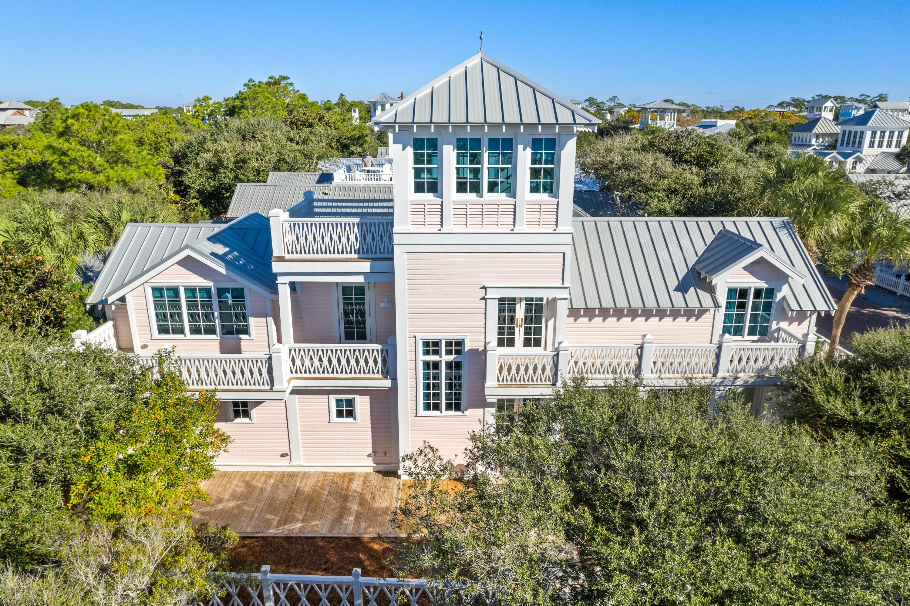 Welcome to your dream beach home, a meticulously renovated five-bedroom, five-bathroom sanctuary in Seaside, Florida. This exceptional property seamlessly blends modern luxury with timeless coastal charm, offering an unparalleled living experience. This home has been thoughtfully renovated inside and out, ensuring every detail meets the highest standards of quality and design. Seldom does a home this perfect and in a prime location become available in Seaside. The interior wood walls and ceiling are painted a crisp white throughout the home.  The master suite, with walk-in closet, plus three additional bedrooms, each with a private bath, can be found on the first level. The master bath features double sinks, quartz countertops, and marble tile. The laundry room is also on the first level and has plenty of storage, an ice maker, and refrigerated drawers for beverages. The second level has the ever-popular open floor plan. The kitchen flows seamlessly into the dining area and into the beautiful, light filled living room.  A unique ceiling design in the living room defines this special space. The spacious galley kitchen includes a 11' quartz breakfast bar, custom made cabinetry and high-end appliances. Off the kitchen is a wet bar with ice maker, refrigerated drawers and a pantry. The fifth bedroom, currently furnished as a media room and a full bath are also on the second level. Framing the second floor on the south side are two decks accessed via the living area and from the kitchen. The jewel in the crown of this lovely home is to ascend the steps to the third level enclosed tower and open sundeck to take in breathtaking gulf and sunset views from this spectacular perch. In addition to the sun deck, enjoy multiple outdoor spaces, ideal for alfresco dining and relaxation. The stunning interior furnishings were carefully selected to enhance the elegant d??cor of every room. Experience immersive audio throughout the home with a surround sound system, ideal for entertaining or relaxing with your favorite music.  Located just a short stroll from Seaside's renowned beaches, boutique shopping, and gourmet dining, this home offers the quintessential coastal lifestyle. Don't miss the opportunity to own this exceptional property in one of Florida's most desirable communities. 