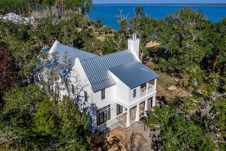 This brand new home began construction in 2019, completed in 2020. The Carlisle plan offers 4 bedrooms with one on the main level, 4 and 1 half bathrooms, a 2-car garage and extraordinary finishes such as wire-brushed oak floors, tongue-and-groove ceiling and brick accents throughout. Enjoy quiet evenings on the wide covered porch with gorgeous views of the Bay. The spacious first floor features an open living area centered around a brick fireplace and grand dining room with decorative wood ceiling beams. The chef's kitchen faces the living/dining area with beautiful pure white quartzite counters,shaker style cabinets,white brick accent wall, Wolf appliances including 48'' 6-burner range and Sub-Zero appliance including side-by-side refrigerator, wine cooler, and ice maker.