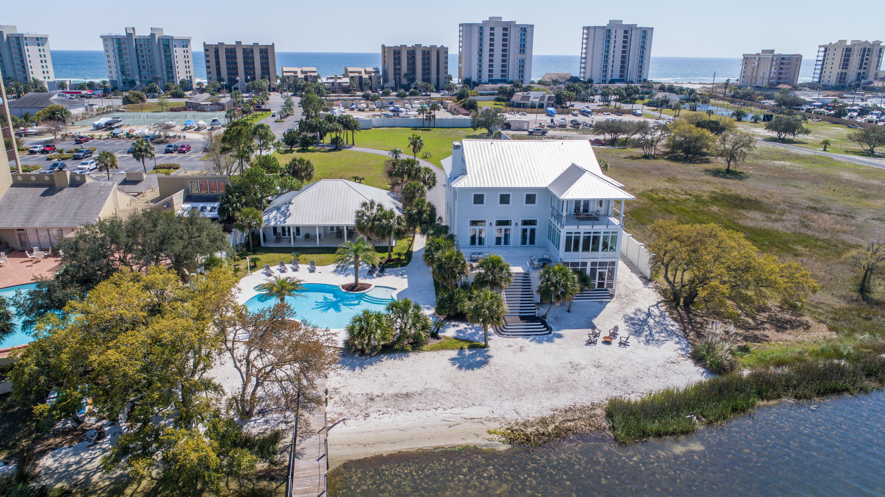 Coastal elegance blends effortlessly with luxurious finishes in this private gated estate in the heart of Perdido Key. Upon entering, you're embraced by views of the Old River; contemporary architecture, lavish finishes and designer furnishings complete both the main & pool house spanning over 8100 sq ft. The epitome of River front living, steps from the gulf, with zoning for 4 more houses & permitted boat house. The main house features 6 bed/6.5 baths, situated over 3 floors, spaciously designed, the river becomes the perfect backdrop & can be seen from nearly every room. From the chef's kitchen, oversized quartzite counters to the custom cabinetry, this estate is like no other & has been completed with the finest materials & custom finishes. Call today for a private viewing.