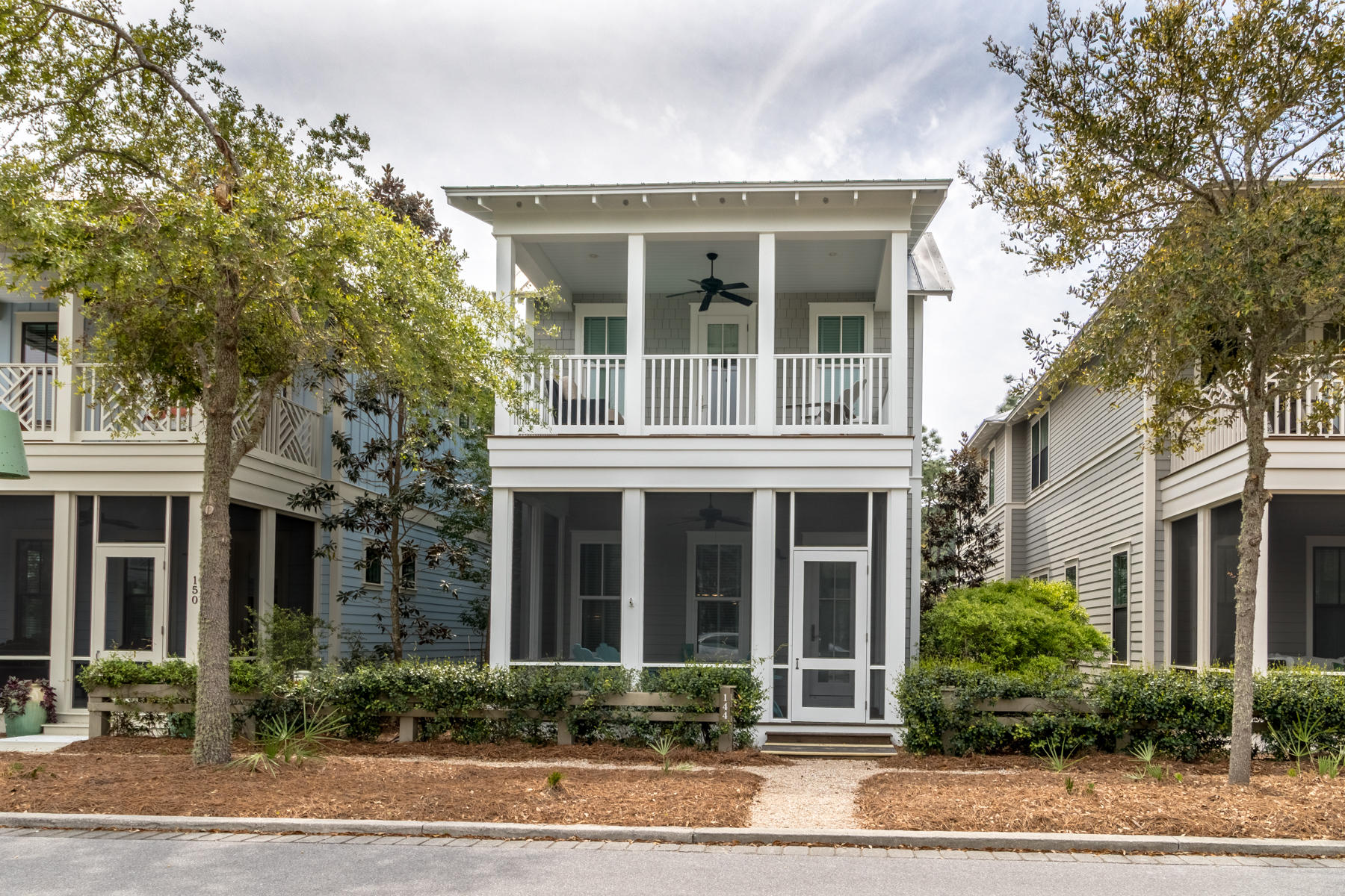 Tucked away in WaterColor's Crossings District, this two-story beach house was made for family beach living with beautiful hardwood floors and an additional living room on the second level. This home offers a prime location just a few doors down from The Crossings pool. Boasting a main floor master bedroom ensuite with dual vanities and a walk-in closet, the first level of the home also offers soaring ceilings, an open concept floor plan and a screened-in front porch that are great for entertaining guests. Completed in partial wainscoting with crown moulding throughout, the large living room opens to the dining with seating for six, and kitchen that features additional seating at the breakfast bar. The spacious kitchen boasts a center island with pendant lighting, custom cabinetry,