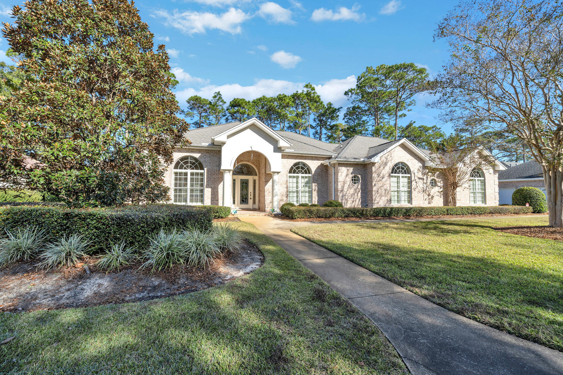 Welcome to this immaculate one-owner custom home in the private gated community of Magnolia Plantation of Bluewater Bay. This home with a NEW roof is located on an oversized .43 acre lot overlooking the former #1 hole of the Magnolia Course and the community lake beyond. This home with its high ceilings and abundance of windows allows the natural light to flow through it. When you enter the wide, welcoming foyer, you will find the formal dining room on the right and a large living room in front of you. Adjacent to these rooms is the large, family sized kitchen that is open to the roomy family room accented by a gas fireplace. Both the living room and the family room offer a wall of windows overlooking the serene back yard. The kitchen features an abundance of cabinets and counter space as