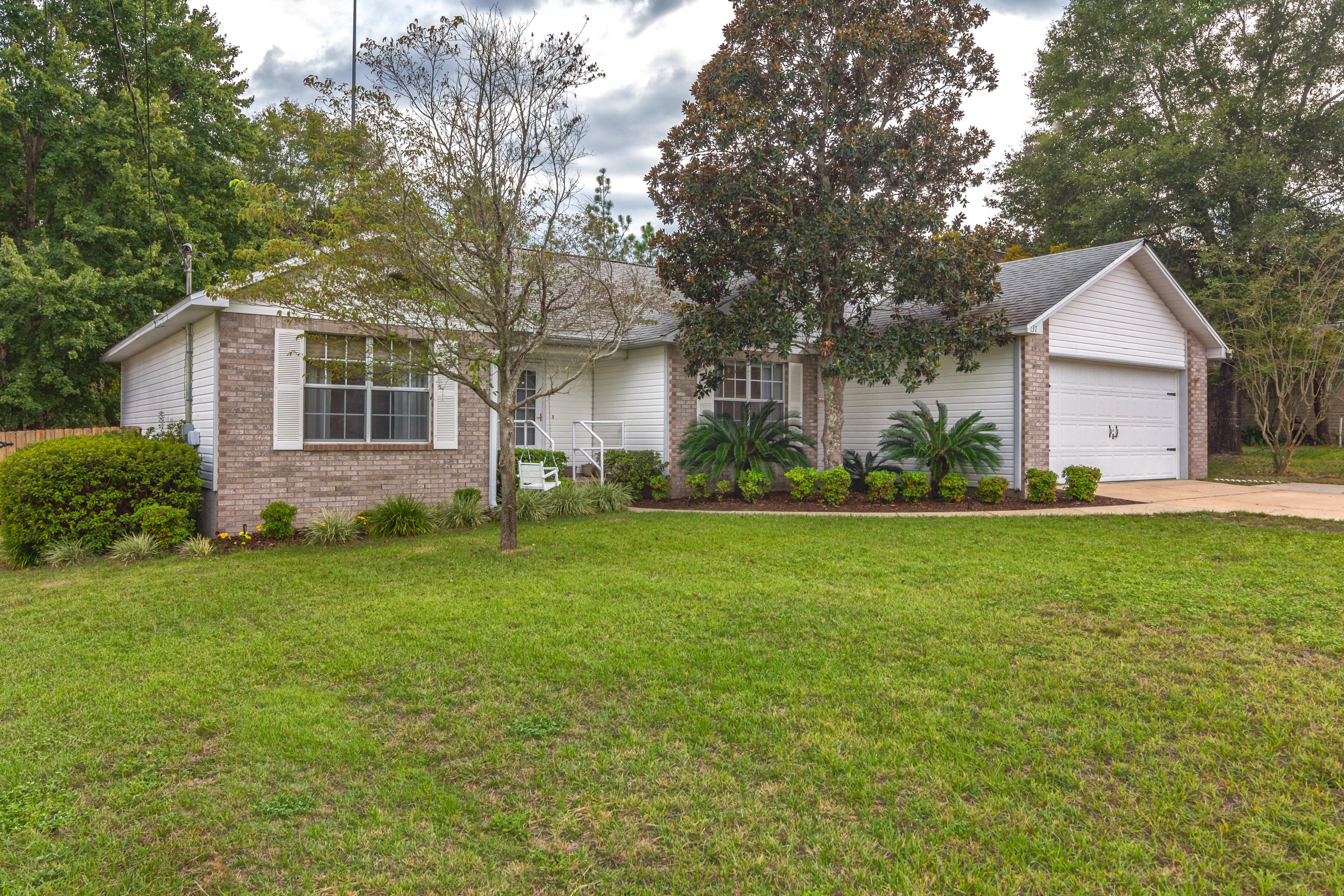 So Beautiful! South Crestview. Come check out this FLAT lot and perfectly maintained home. Drive up and park with ease on the additional poured concrete. Enter to a delightful foyer with space for that swoon-worthy bench and coat rack. Cathedral ceilings delight in the open floorplan. Upgraded lighting, diagonal laid wood surface floors, grey walls, and a herringbone tiled fireplace please the eyes. Kitchen is generous with ample pantry, tile floors, and bright white cabinetry. 3 Bedrooms are featured, with a split floor-plan for privacy. The Master bedroom is extensive with his and her closets, one of them large enough to live in! The Master bath features double vanities, garden tub and separate shower, as well as tile floors. Both additional bedrooms are large and feature the same perfect flooring. Outside you will love entertaining with the screened porch, pergola, concrete open patio and fenced yard, great for pets too! An additional storage building and shed complete with electric, waiting for your inspiration!