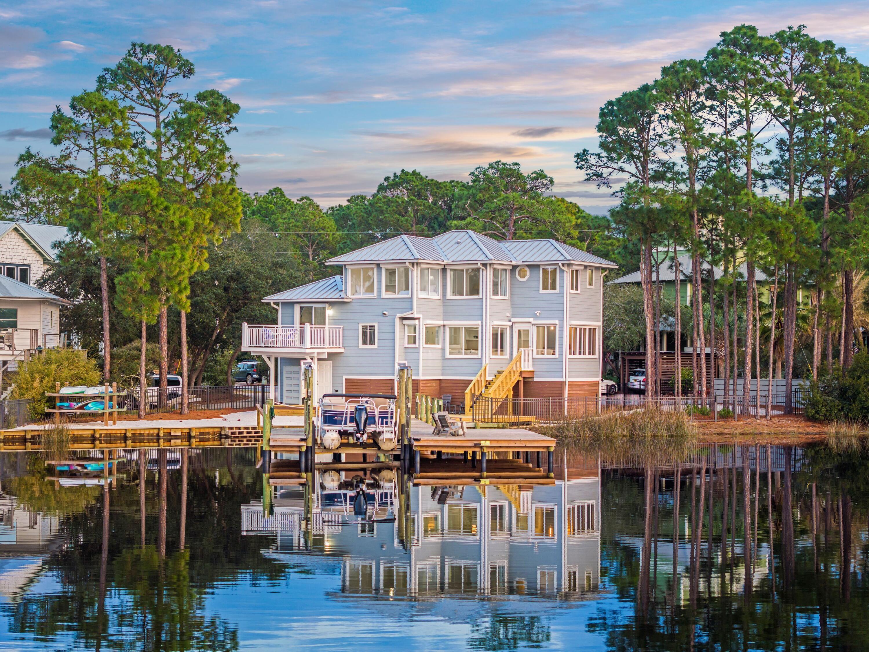 Nestled along the shores of Eastern Lake, one of South Walton's rare coastal dune lakes, 120 Shannon Drive is a waterfront retreat offering stunning sunset views and expansive lakefront scenery. Located on a quiet cul-de-sac in Seagrove Beach along Scenic Highway 30A, this home provides direct water access with a private dock and boat lift, allowing for kayaking, paddle boarding, and boating straight to the beach, where you can pull your boat onto the sandy shore and carry your chairs and beach gear for a day of relaxation. Designed for comfortable and inviting waterfront living, this four-bedroom, two-bathroom home features an efficient open layout with large windows that maximize natural light and lake views. The kitchen is well-appointed, offering high-end appliances, quartz countertops, and custom cabinetry, all flowing into the living and dining areas for an easygoing, functional space. The primary suite provides a peaceful lakeside retreat with expansive water views and an en-suite bath featuring a jetted tub, walk-in shower, and dual vanities.
Outdoor living is a highlight, with a spacious back deck that seamlessly connects to the newly built, oversized dock, perfect for enjoying lakefront sunsets and entertaining. The sandy backyard blends naturally with the lakefront setting, and the fenced yard offers convenience for pets.
Offering low-maintenance coastal living, 120 Shannon Drive is a rare opportunity to own a true lakefront retreat with direct Gulf access.