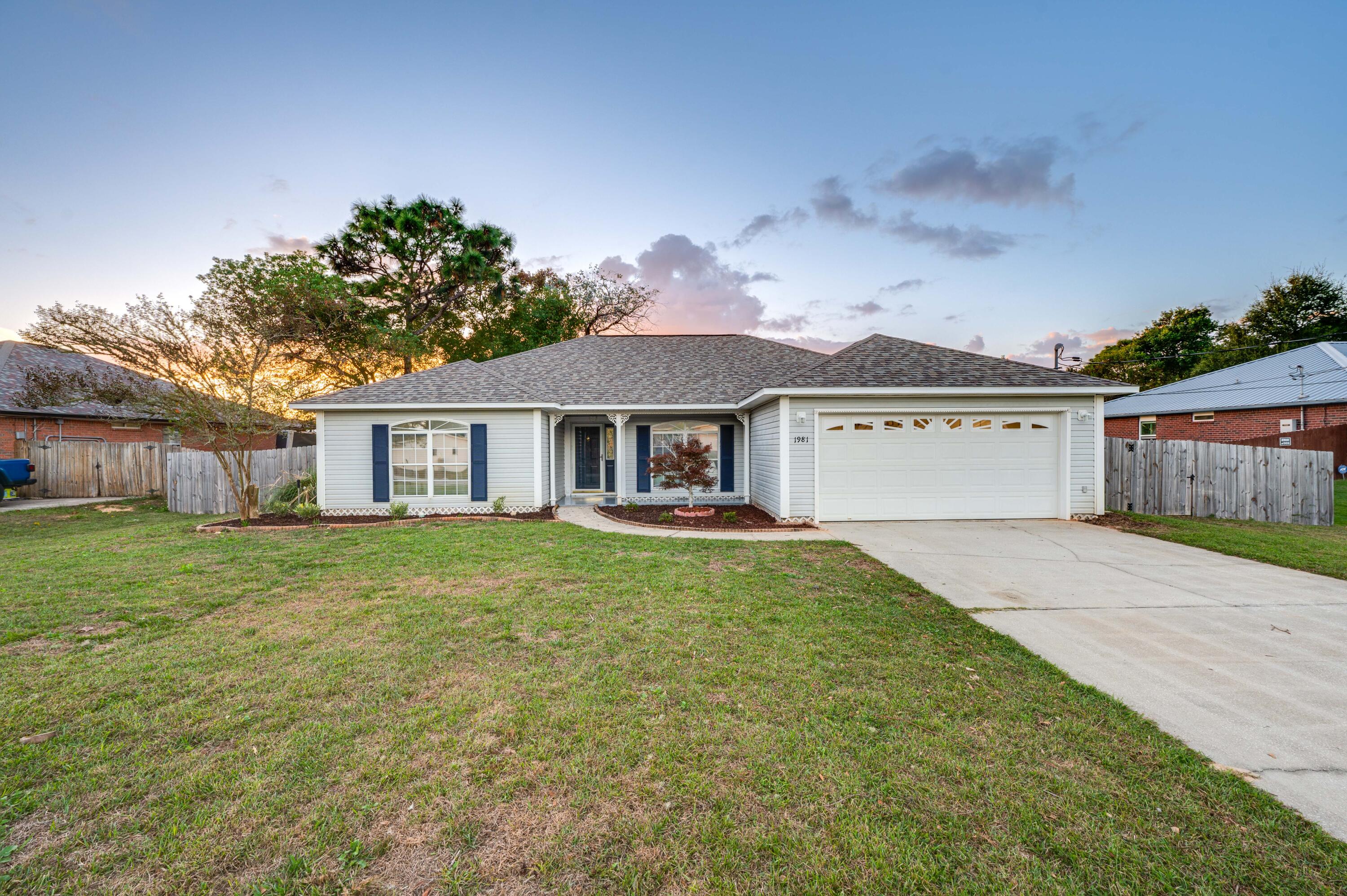 3 bed / 2 bath Split Floor Plan with a designated office in Holley by the Sea, NavarreEnter your warm, inviting home with new wood-look LVP flooring and entryway illuminated by sidelight.  To the right is a dining area with a large  window topped with an elliptical sunburst.  Elegant design features continue in the living room with high, sloped ceilings; crown molding; and a triple bank of windows at the rear of the home, unifying the living space with abundant natural light, opening to a large, privacy fenced-in backyard.  Off of the living area is a breakfast nook overlooked by an L-shaped quartz countertop.