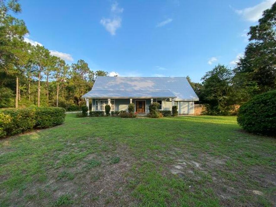 This beautiful wooded country setting containing 2.01 acres is very private but also very close to town! Large updated home contains 3197 square feet and features 5 bedrooms and 4 full baths. The fifth bedroom is accessed by a set of stairs from the garage (both the garage and this room are heated and cooled). The upstairs room could be a guest room, office, studio, gym, or you might have another use for it! There are actually two master bedrooms if you so desire. One is on the main floor. There is also another  roomy bedroom and bath on the main floor which, due to it's location, would make a great mother-in law suite or guest suite!  Upstairs are two large bedrooms. One is extra roomy and it's bathroom has a whirlpool tub and separate tiled shower and could be a second master. It has a