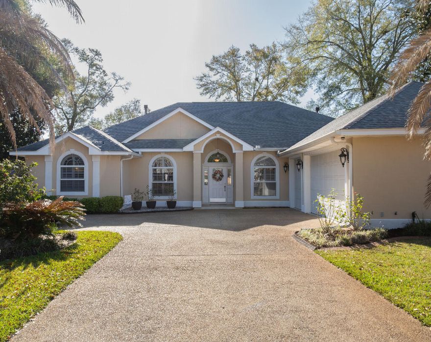 Spacious 4-bedroom, 3-bath home at the end of a cul-de-sac on 1.5 lots (0.38 acres) on a child-friendly street in the desirable Blue Water Bay neighborhood. Featuring soaring 10-12 ft ceilings, an open floor plan, solid wood cabinets, and granite counters with stainless steel appliances. The master suite includes his and her separate closets and sinks/vanities with separate shower and oversized bath. The home opens to a spacious screened-in lanai that opens onto a large string-lighted patio, over-sized yard connected to park greenspace, and large garden area. Park safely in the 4-car driveway or 3-car garage. Automatic in-ground sprinkling system with separate well. Recent Updates: exterior painted (2025); new HVAC (2023/10 yr warranty); new water heater (2021); new roof (2021/10 yr warranty.
