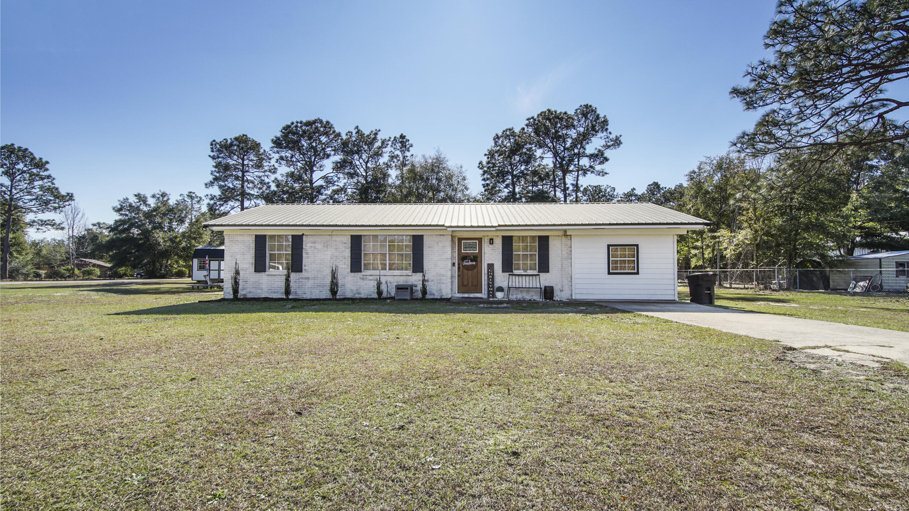 Cute as a button, 4 beds/1 Bath on 1 acre on a corner lot! Located 5 minutes to downtown DeFuniak Springs, this brick home with metal roof is move in ready. It has been updated to include new paint, luxury vinyl plank flooring, lighting, doors and fixtures throughout. The wood accent wall in the living room creates a charming focal point upon entry. The all new full bath is stylish and functional, with subway tile tub surround and new vanity. Additionally, the master suite has space to create a true master bath also. The level corner lot has tons of space to add extra buildings for storage or workshop - and even room for a pool too. This affordable home is located in a great neighborhood, with no HOA and is nearby to schools, parks and shopping. Qualifies for all types of financing also.