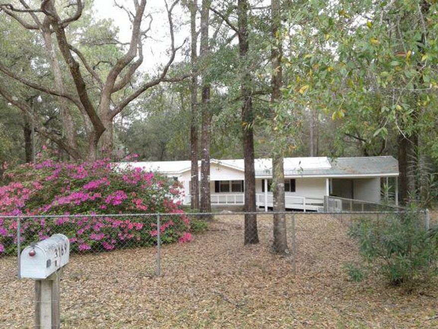 Over 2 acres of your quiet oasis! Charming and cozy, this welmobile home is located on a partially wooded lot situated on a quiet cul-de-sac. Open floor plan and cathedral ceilings make this home a diamond in the rough as a little TLC is needed. Built in buffet server in the kitchen area, kitchen island with cooktop, and a built in oven and desk make for a nice kitchen space. Kitchen cabinets are deluxe cherry with white pulls. The master bath is spacious with a large walk in shower and dual vanity sinks. Step out back and enjoythe sunrise and sunsets under the large beautiful wood deck, great for relaxing or having friends over. The front porch is handicap accessible with a ramp, even a small ramp for pets with lots of parking, outside security lights, and space to store boats or RV