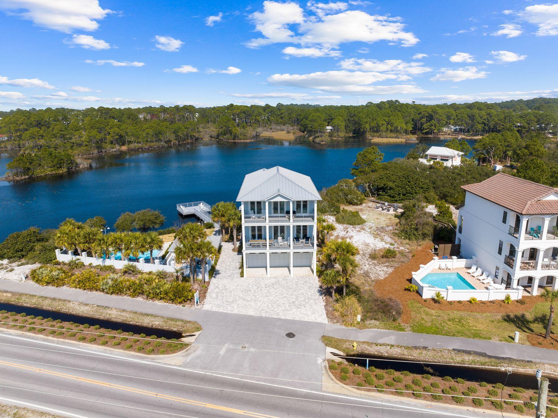 Aptly named 30A Fish Camp, this six-bedroom sanctuary situated right on Scenic Highway 30A boasts 200 feet of coastal dune lake frontage and beach access right across the street. The main living area, perched on the second floor, offers seamless flow between living, kitchen and dining spaces, leading to a sprawling balcony overlooking 30A and the Gulf of Mexico. The kitchen boasts polished granite countertops, porcelain farm-style sink, stainless steel appliances including gas range, a sizable island, breakfast bar seating and a formal dining table for twelve. Four of the bedrooms feature king-sized beds, three with ensuite bathrooms, while two additional bedrooms offer bunk bed setups ideal for families. The primary and junior primary suites offer breathtaking views of the Gulf of Mexico with decor in calming neutrals and soft teals. Step outside to discover a private resort-style pool overlooking the coastal dune lake, complete with a private dock and a fully equipped outdoor kitchen pavilion, perfect for entertaining. With a three-car garage and ample driveway parking, this home offers both luxury and convenience. Positioned on a .45-acre lot adjacent to the Dune Allen beach access, this home's location is simply unparalleled. Enjoy easy access to exceptional shopping, dining, state parks, and bike trails that 30A has to offer. There's simply no place like 30A Fish Camp, where luxury meets leisure.