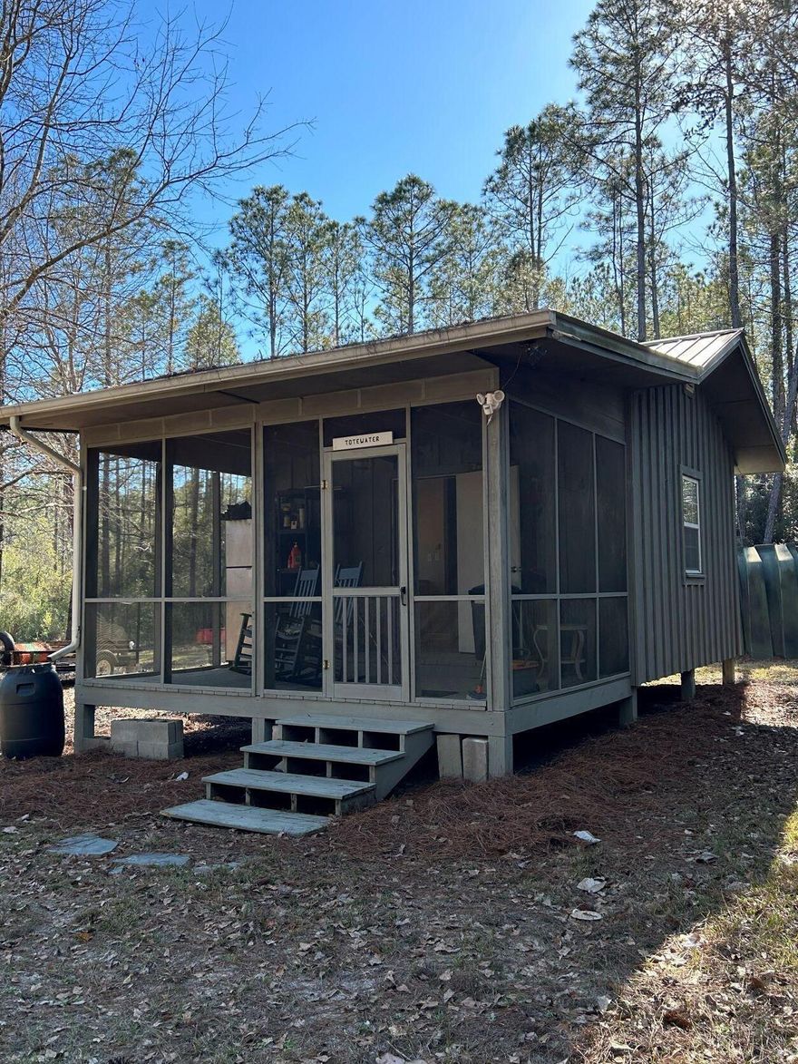 UNDER CONTRACT and accepting back up offers. Intrigued with living off the grid, or glamping at the next level? This 12.5-acre lot is located in the gated recreational subdivision of Walton Plantation. Approximately 3 acres are cleared land. The property comes complete with a 256 square foot board and batten cabin. Features include a propane heater w/ wall mounted thermostat, propane stove and cooktop, propane refrigerator, propane on demand water heater, propane tank, gas generator, electric window AC, microwave, composting toilet, 300 gallon water storage tank, water pressure tank with 12v water pump, shower, sink and ceiling fans. Walton Plantation is a private community and includes hunting, fishing, a chapel for gatherings, community well and dumpsters for trash disposal, restrooms, ponds, garden, horseback riding and ATV trails. Owners may join the hunt club for an additional fee, allowing access to approximately 2,000 acres.  Info is believed to be accurate but should be verified. Ditch the sports car and jump in your 4 wheel drive to escape to your own paradise in the pines. Zoning for parcel is 1-acre SFR and 11.5 AC Non-Ag. 