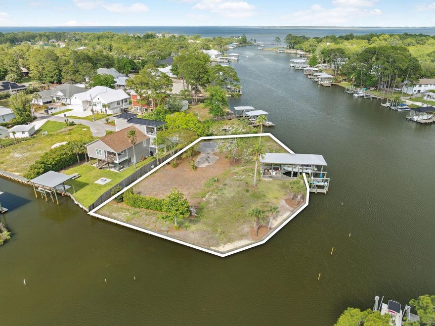 Nestled along the tranquil shores and deep waters of Buck Bayou in the heart of Santa Rosa Beach, this exceptional half-acre lot offers the perfect blend of privacy and access to the vibrant coastal lifestyle with a generously-sized boat slip measuring up to 52 feet. With approximately 330 feet of pristine water frontage entirely bordered by a seawall, this property boasts panoramic bayou views, setting the stage for stunning sunsets and serene water vistas. Water enthusiasts will appreciate the expansive dock, complete with a boathouse and two boat lifts, providing direct access to the bay and beyond. This protected bayou location ensures calm waters for boating, paddleboarding, and kayaking, while still offering the potential for sweeping water views from a future residence.  Conveniently situated just minutes from the world-renowned beaches of 30A, the upscale shops and dining of Grand Boulevard, and the amenities of Sandestin, this prime location seamlessly blends natural beauty with modern convenience. Whether you envision a waterfront retreat or a luxurious primary residence, this unique property provides a rare opportunity to create a coastal sanctuary with unparalleled water access and stunning views.