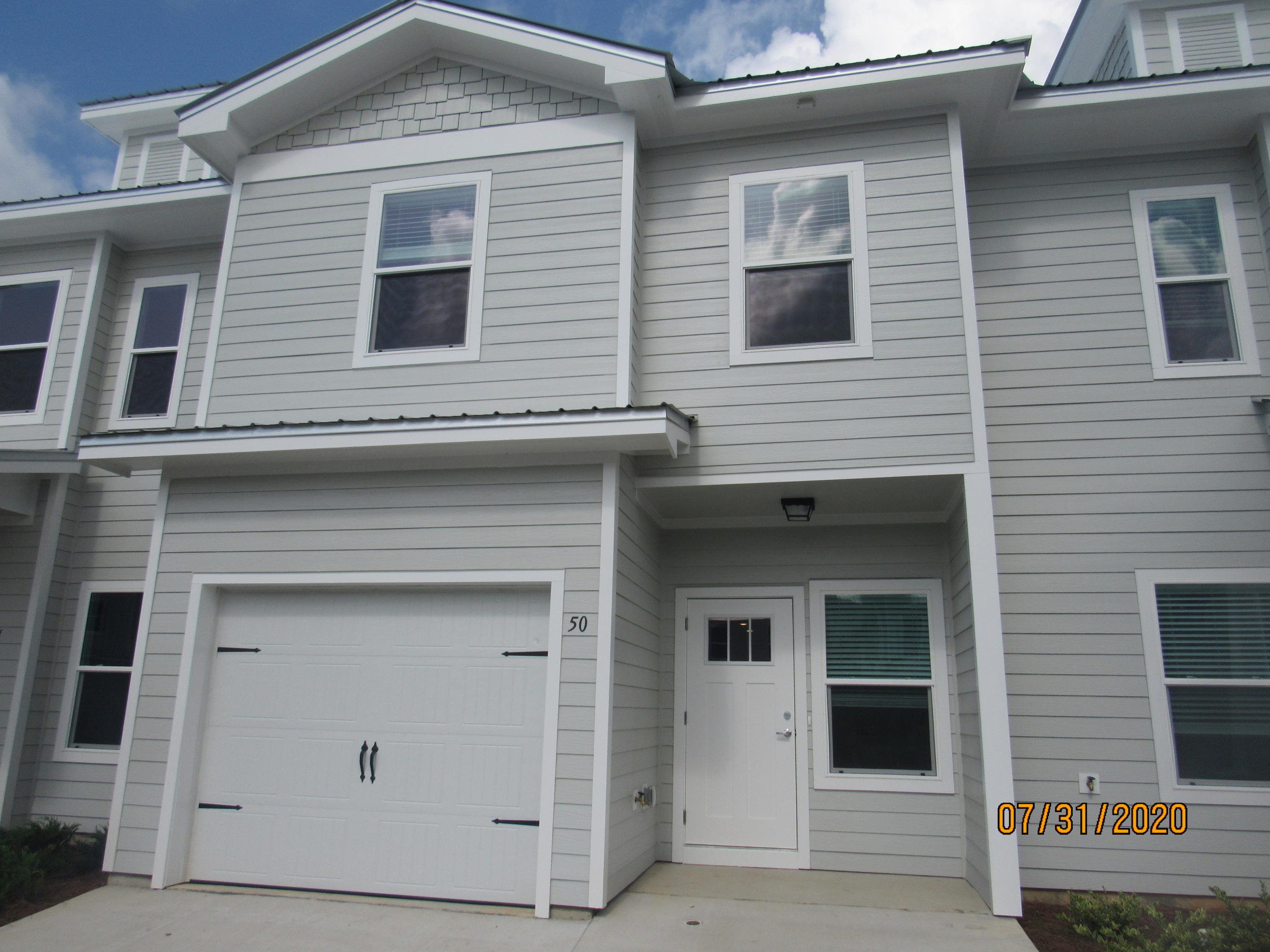 2020 build, this lovely townhome has 3 bedrooms, 2.5 baths upgrades, a *garage*, and there is a community pool! This fantastic home is a stone's throw from the elementary school, just a few miles from a Publix shopping center, and a short, easy commute to the sugar sand beaches and emerald waters of 30a/SOWAL. It has neutral paint and no carpet throughout. The open floor plan on the first level includes a nice size living room with nook, eat-in kitchen with breakfast bar, gorgeous counter tops, plenty of counter/cabinet space, stainless appliances (including a flat cook top stove), beautiful back splash, and a pantry, as well as a half guest bath with pedestal sink and a screened-in back porch. Upstairs, you will find the master bedroom, complete with a walk-in closet and en suite with