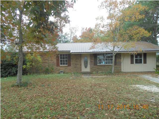 PRICE REDUCED TO $55,900!! Must See! Brick home fronting paved road conveniently located in neighborhood near schools and town. Home has metal roof, central heat/air, carpet and tile floors. All bedrooms and baths are on one side of home. Den and utility room on other end of home. Nice back yard with patio. Concrete parking pad. No appliances.