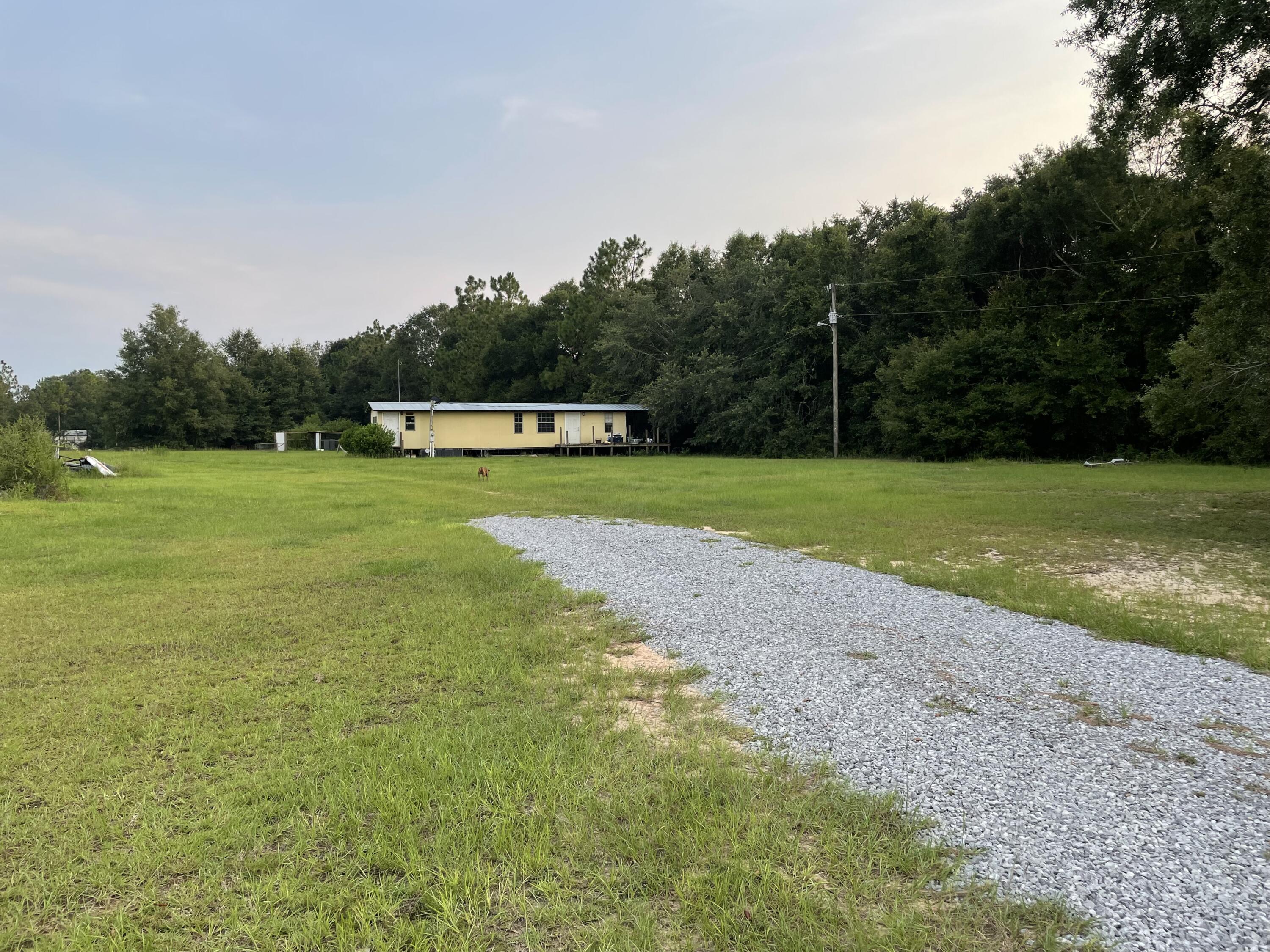 Exceptional opportunity to make your country dream a reality on this 1.06 acre property perfectly situated with easy access to Blackwater State Park, Milton, Interstate 10, beaches, Pensacola and military bases - the options are wide open with this blank slate. There is a single-wide trailer that needs some attention to be livable or transformed into a workspace. The value is in the level cleared land. The property has 2 power poles (disconnected from grid), 2 septic tanks, water and high speed fiber optic internet is available.