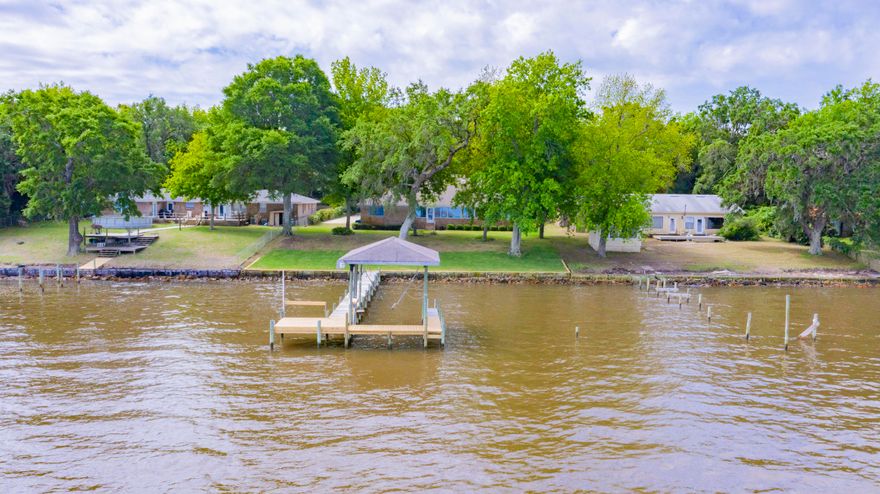 Located in Gulf Breeze, this perfectly maintained home with one owner, is situated on a large Bay front lot. Upon arrival, you'll note the magestic towering Oak trees lining the street and yard and long driveway perfect for extra guest parking while entertaining. This home features an open-split floor plan and has vaulted ceilings giving for a nice open feel, formal dining room and office, 3 car garage, hurricane shutters, wood burning fireplace, and a wonderful over-sized sun room encompassed by windows providing endless views of the Bay. The third bathroom is also right off the Florida room with a walk-in shower providing easy clean up after coming in from the boat. The kitchen comes fully equipped with a breakfast bar and nook, built-in pantry with pull out shelving and corian counter