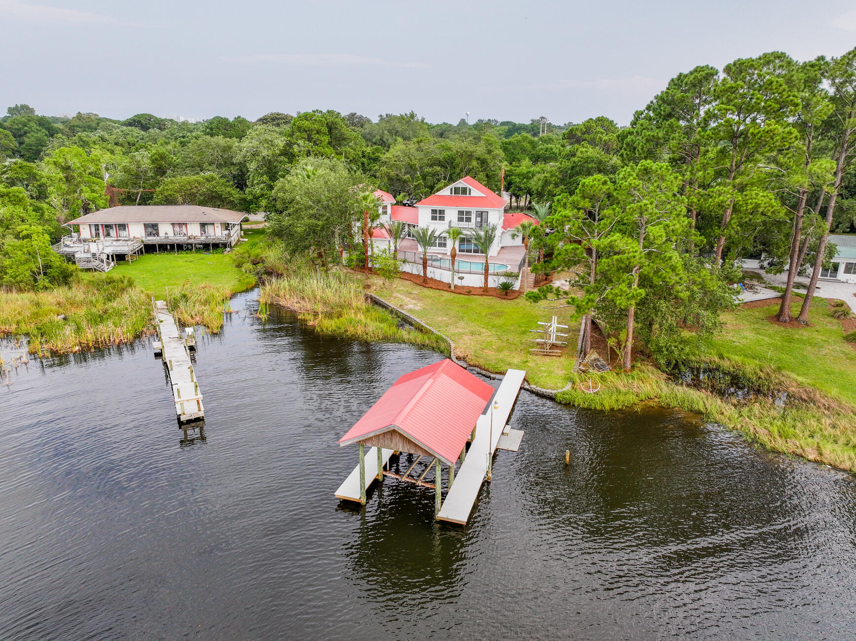 Waterfront, Pool, carriage house ..Deep Water-Dock. 2007 Metal Roof! 20 yrs Life per 4pt. 3 good ac units, one new! 2 new hot water heaters. Pool Pump and Salt Cell Replaced. Truly One of a kind home in Destin. 5BD/6BA Estate Home located on Marler Bayou in the city of Destin, FL. Deep Water, Stunning Views. Finished Dock with Boat Slip. Enjoy relaxing & entertaining outside by the Pool and Jacuzzi hot tub with access to the half bath and the Dry Sauna. Main House has 4 large Bedrooms and 4 updated bathrooms, cherry hardwood flooring. Beautiful Iron staircase upon your entrance, multiple living spaces and lots of storage. Plus you have a 1BD/1BA Mother-in-Law Suite/Cottage for your guests with a LR