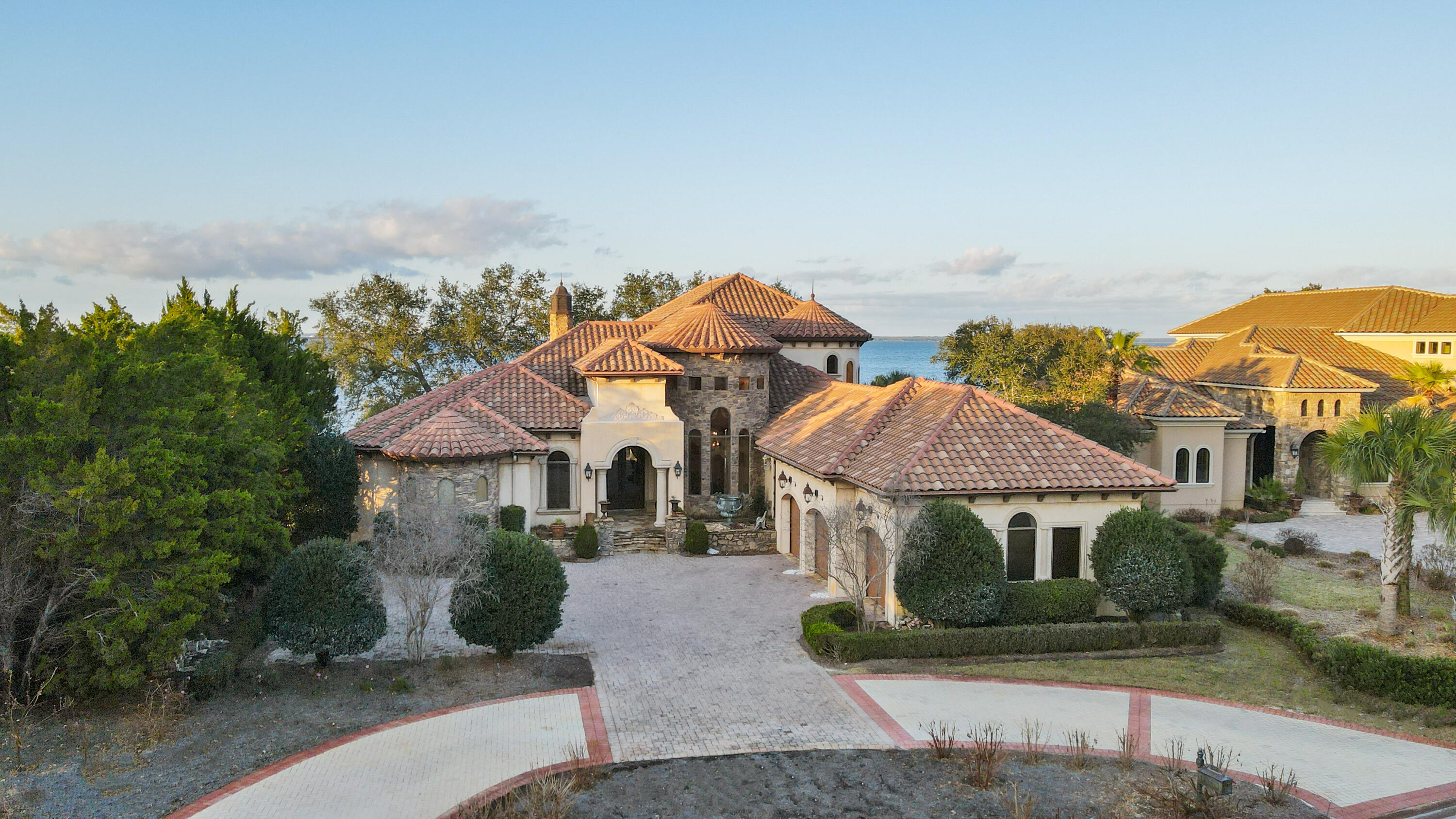 This American Dream home was featured on a national TV show called American dream homes, on the Discovery channel. This Home is considered to be a premier property in Regatta Bay, because it has lake views from the front and Panoramic Bay views from the back. Breathtaking sunsets await, for the future owners of this magnificent home. This executive estate offers easy golf cart access to the beach This ICF-constructed architectural beauty unites the distinctive details of a stately chateau-style home with modern, coastal themes for an awe-inspiring waterfront experience. Situated on 118 feet of desirable shoreline, this estate features an abundance of alfresco living including an almost 1200-sq-ft screened-in lanai with heated, saltwater pool, spa, summer kitchen, and outdoor fireplace.