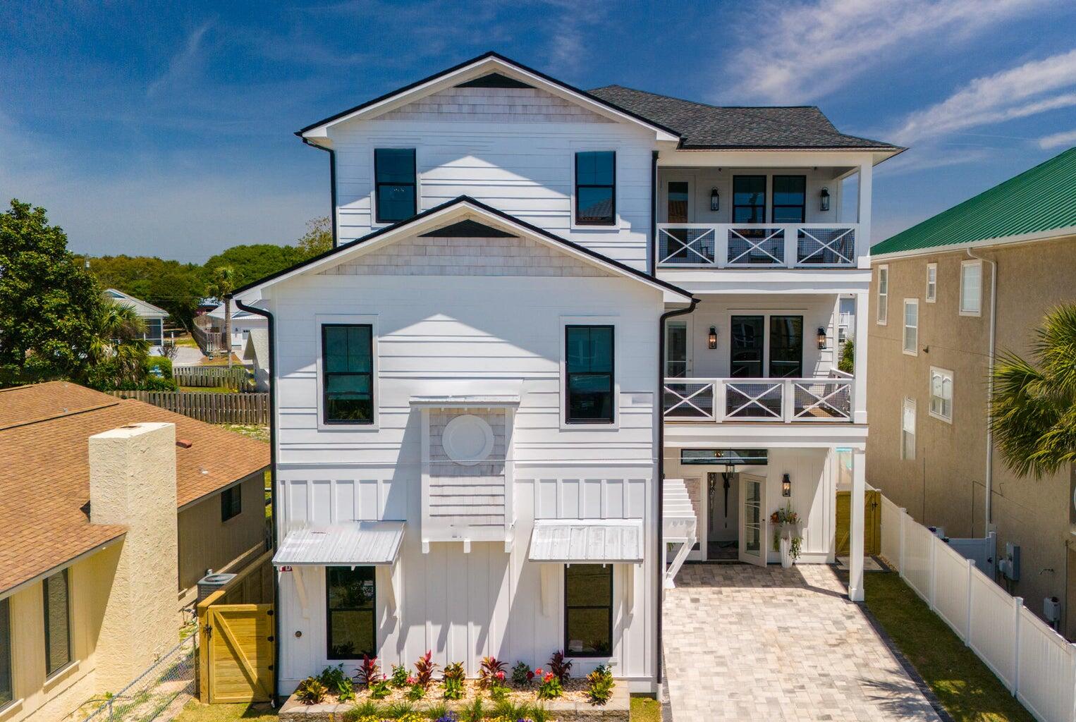 Colors are the smiles of nature! The array of colors throughout this home makes you feel like you are walking through a garden. Each room has its own color palette to energize and soothe you. This custom beach house has left nothing to the imagination and utilizes each nook and cranny into functional areas. Boasting 9 bedrooms with enough space to accommodate 21 persons, the home is spacious and has places for each one with freedom to spread out. Each of the 3 floors have bedrooms and full bathrooms and other areas to entertain or relax. The kitchen and living space are located towards the back of the home. A beautiful lanai and covered porch enhances outdoor entertaining around the in ground pool and putting green. The lanai has built in fire place and outdoor kitchen to keep to the