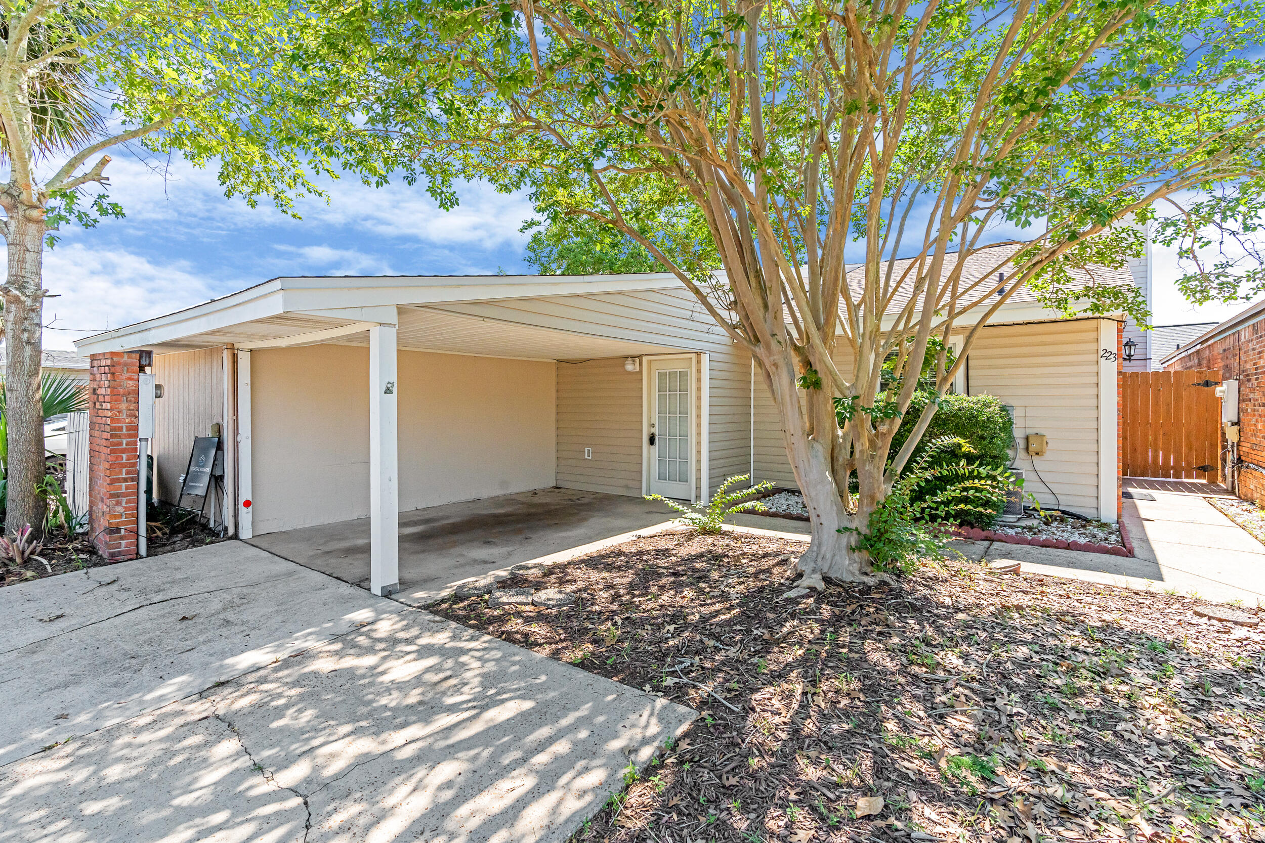 Centrally located Destin townhome less than 3 miles to the beach, 1 mile to the new Publix, and 15 miles to Eglin AFB and Hurlburt Field. This 2 bedroom, 1.5 bathroom duplex features vaulted ceilings, a wood-burning fireplace with brick accent, lots of natural light, and an open layout. Tiled floors in the kitchen, dining, bathrooms, and guest room. New carpet in the living area and primary bedroom. Laundry in unit, washer and dryer convey. Ensuite bathroom has new vanity, toilet, and shower/tub insert. Enjoy an attached carport, a fully fenced backyard with a freshly stained deck, and no HOA. Tucked near back roads for easy access around town, this Destin gem is ideal for first-time buyers, investors, or military relocation.