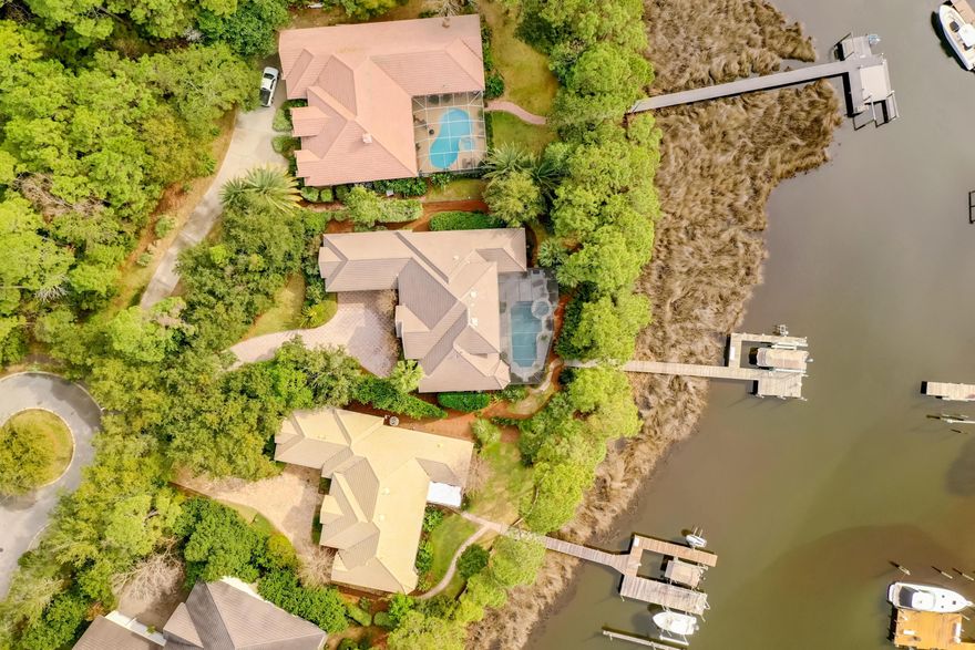 This immaculate waterfront home is like buying new construction. Fresh paint, new flooring, updated kitchen, updated outdoor kitchen, updated master bath, the list goes on and on. On deep water with large dock that accepts a 45+ ft. boat on one side and a 16,000 lb lift on the other, with 30 & 50 amp service - a boater's dream. Fabulous covered lanai w/pool/spa, outdoor kitchen and lush landscaping. Inside the living/great room opens to the pool area with triple sliding doors, bringing the outdoors in and creating the perfect FL lifestyle. Wet bar, wine cellar, gas fire place, breakfast area, formal dining room, home office, and screened balcony off the 2 upper bedrooms gives fantastic views of the bayou. This home also has tons of storage to keep you completely organized. Buyer to verify