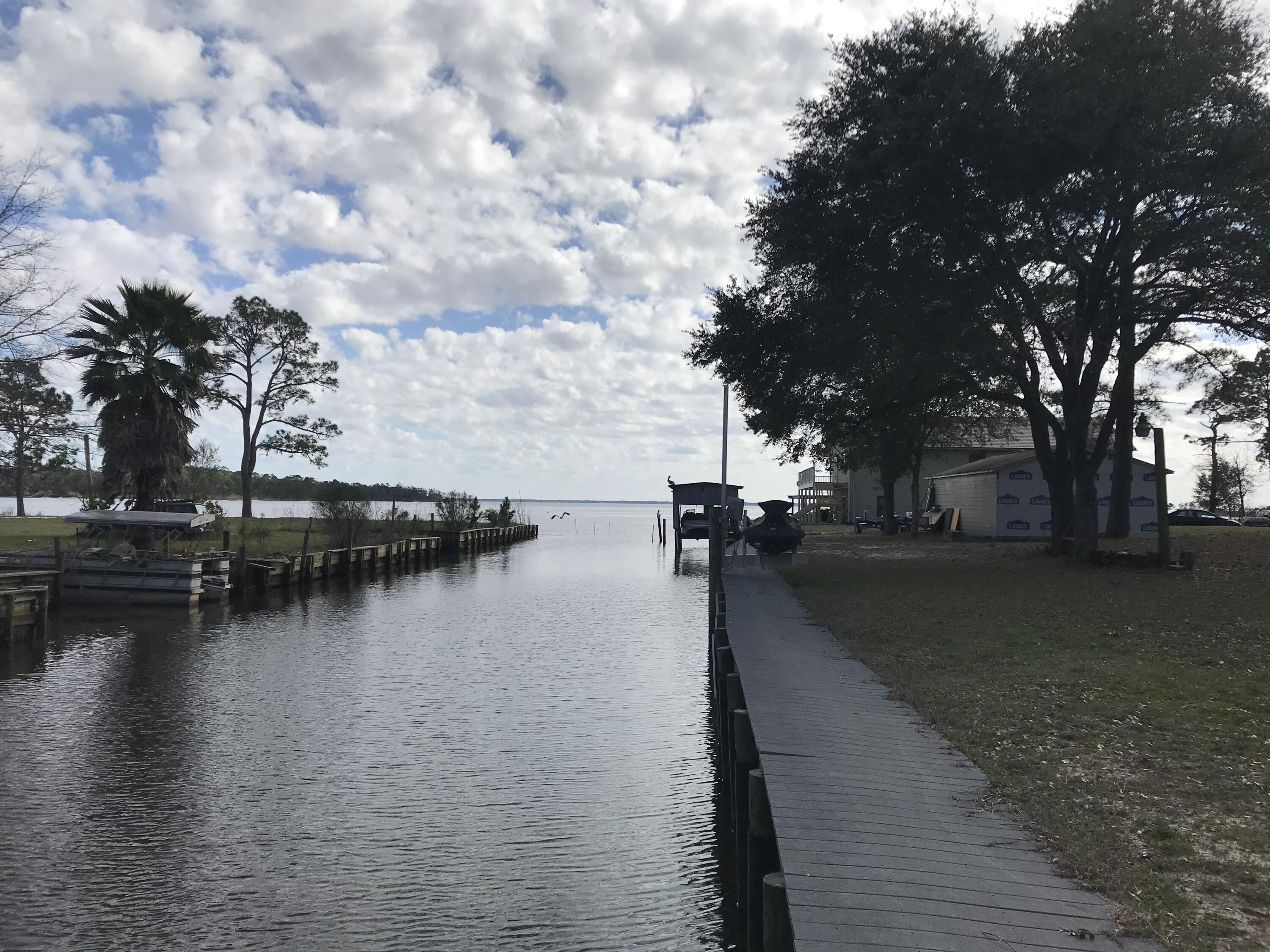 THIS HOUSE ON TWO WATERFRONT LOTS JUST A STONES THROW TO ALAQUA BAYOU WOULD MAKE A GREAT HOME. THE LOT HAS SOME BEAUTIFUL LARGE OAKS SHADING IT.  NEW PAINT AND FLOORING. THE BATH HAS A LARGE TILE SHOWER. THE HOUSE FEATURES AN EXTRA WIDE HALL. THERE IS A 19X8 PATIO OVERLOOKING THE CANAL. HURRY!  THIS HOUSE WILL NOT LAST LONG!