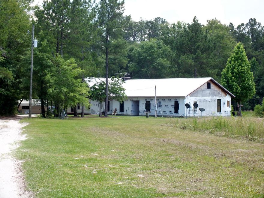Two houses under one roof on 10 acres with 2 ponds in a secluded area of Walton Co. The larger 1864 sqft house has 2 stories with a rustic interior. It has 3 bedrooms, 2 bathrooms, a great room, kitchen, dining area, and laundry area. The smaller 992 sqft house features an open floor plan, 2 bedrooms and 1 bathroom. Both houses require some interior work, such as flooring and heating and air conditioning systems. The exterior of both houses requires siding and the covered breezeway needs to be finished. There is also a metal workshop and a pole storage shed on the property.