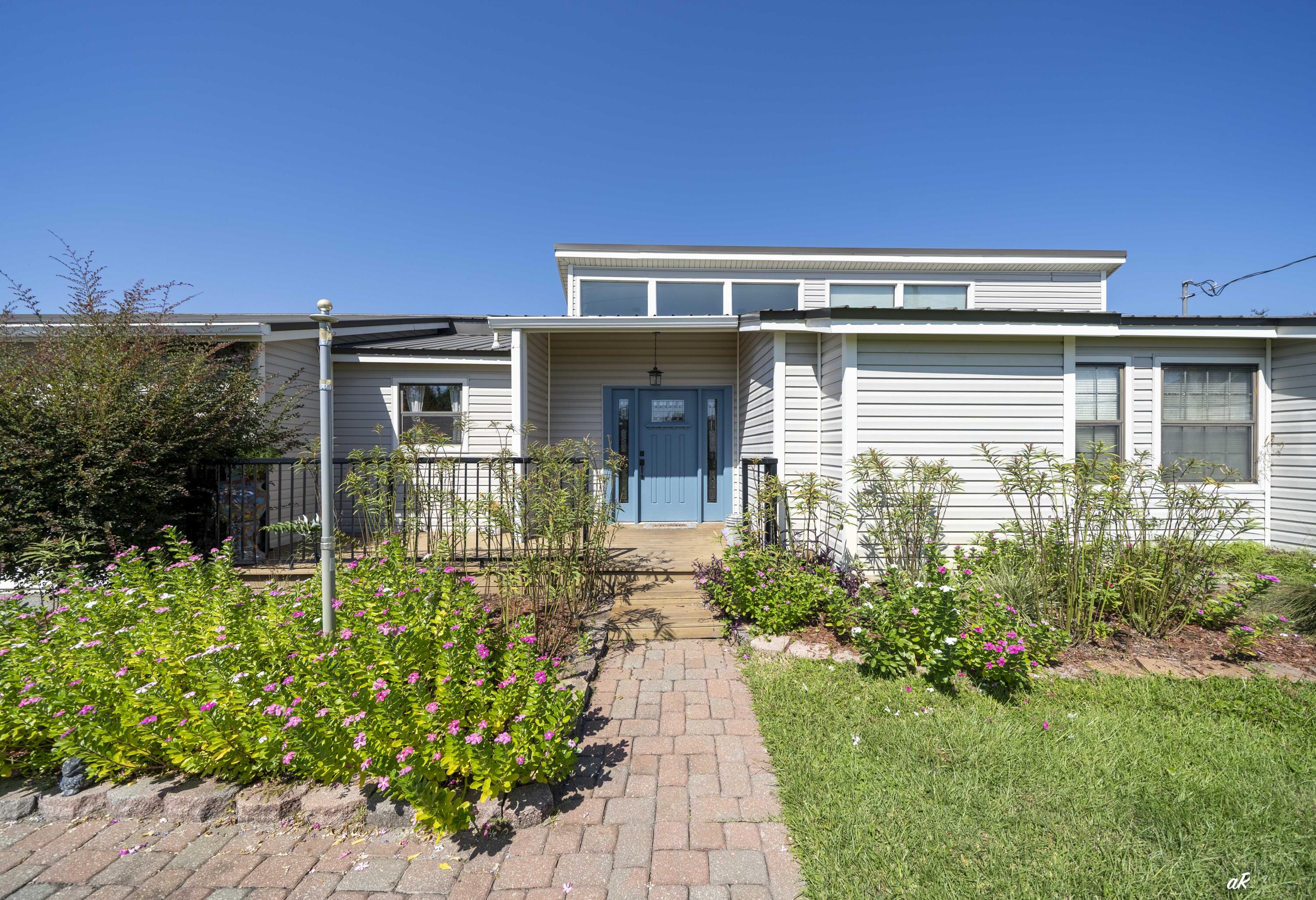 Welcome to your dream home on the outskirts of Panama City! Just 21/2 miles from 23rd Street dining and shopping, this beautifully maintained 3BR/2BA, 2,322 sq ft home features a durable metal roof, solar panels, and no HOA. Inside, the sunken living room boasts soaring 23-ft vaulted ceilings, natural light, and built-in bookshelves. The remodeled kitchen offers quartz countertops, stainless appliances, induction cooktop, mobile island, and walk-in pantry. The master suite includes vaulted ceilings, dual walk-in closets, and a large bath with double sinks, walk-around shower, soaking tub, and patio access. Two additional bedrooms share a farmhouse-style bath with a clawfoot tub. Outdoor living shines with a 683 sq ft deck, 16x16 screened porch, 20x25 bar/workshop, and smokehouse. his home is move-in ready and waiting for its new owners.