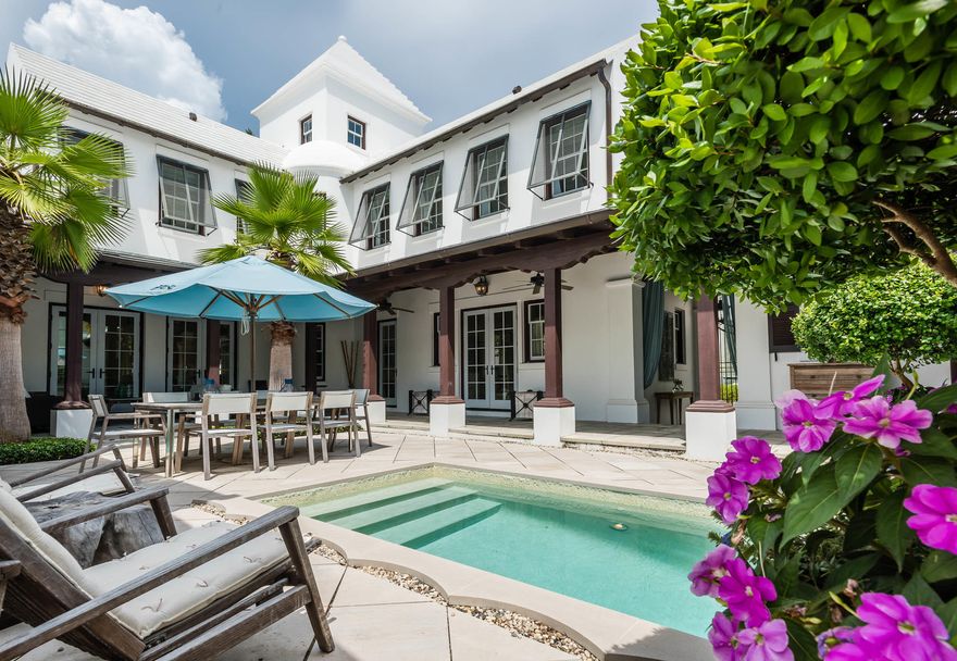 Once featured in Veranda Magazine, this awe inspiring Steve Mouzon Design features impeccable furnishings by interior designer, Georgia Carlee. The home surrounds the large courtyard allowing for outdoor dining, sunning, and shade. The first floor master suite, living and dining rooms, followed by the kitchen feature expansive windows which look upon the beautiful courtyard and pool.Entertaining is a cinch! The professionally equipped kitchen, featuring a 48 Wolf Range accompanied by the Sub-Zero Refrigerator, opens to the dining room creating the perfect hosting scenario. White-washed cherry cabinets above and below the Azul Imperial granite countertops create beauty while dining. The palette of white, sand, and pale blues is a perfect ambiance to this stunning home.A soo