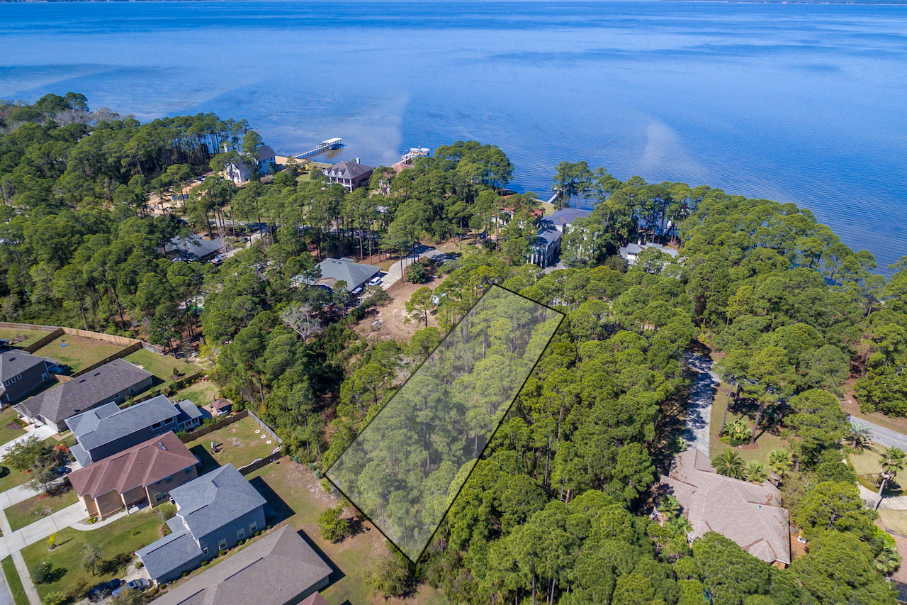 A gem of a homesite with mature towering trees. Whether you choose to build a cozy bungalow, classy contemporary, or rustic ranch, flexibility reigns here. Capitalize on bay water views, across the street, while preserving a natural woodland of privacy. With 0.624 acres you have space galore for your house plan. Have fun designing window placement to capture the changing light of the day and to maximize natural air flow. A 2-story home would maximize water views while a one-story abode would have all the advantages of single story living. With its park-like setting you will have the creative freedom not often found in this region. This lot is located near the point of a charming peninsula enveloped by Choctawhatchee Bay. While you will revel in the privacy, this bay front community is