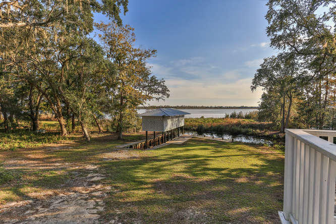 Bay living at its best found in this charming southern style home in Jolly Bay off Pitts Bayshore drive. Hardwood floors, crown molding, fireplace, large entertainment kitchen overlooking the bay with outdoor living screen porch. It sits on a Large lot with super huge boat house with two boat lifts on canal providing super protection from storms but has its own Bayfront island access. Three bedroom, two bath, with lots of expansion possibilities. Huge acre lot with hundred year old oak trees. A must see in a quiet dead-end . neighborhood. Includes separate island parcel.