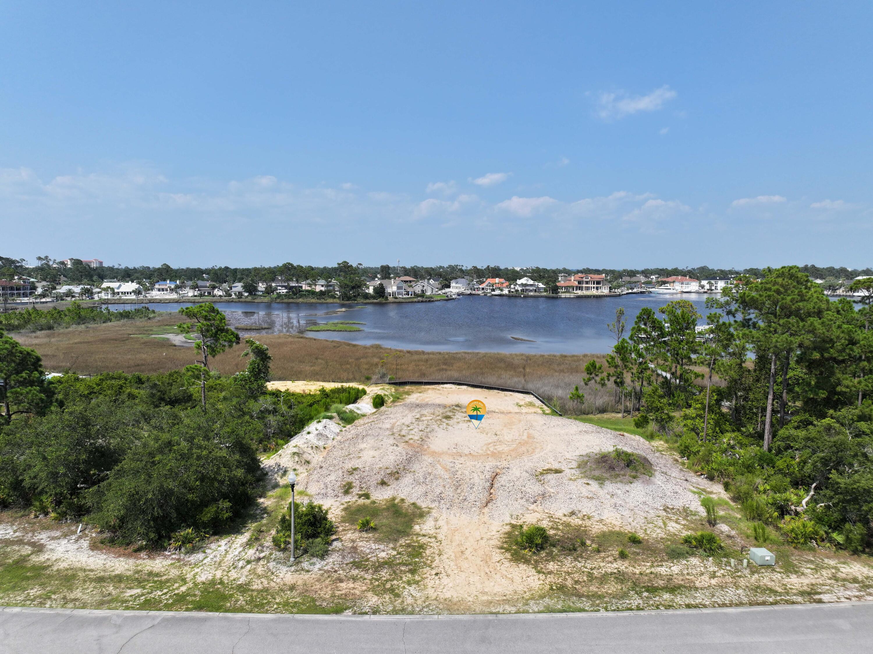 This gorgeous homesite has been cleared and is ready for you build your dream waterfront home on Grand Lagoon! Welcome to Finisterre , a gated waterfront neighborhood with fabulous amenities and perfect location where you can walk to nearby restaurants. Enjoy amenities such as tennis, pickleball, basketball, a playground, and community dock. So close to restaurants, grocery, St Andrews State Park, boating, and of course, the beautiful beaches of Panama City Beach! The adjacent lot is also for sale (see MLS #966107), offering you the opportunity to obtain 2 side by side lots in one of the most prestigious neighborhoods in Bay County. Please check in to utilities or any measurements to confirm information.  Call today to get started on your new home!