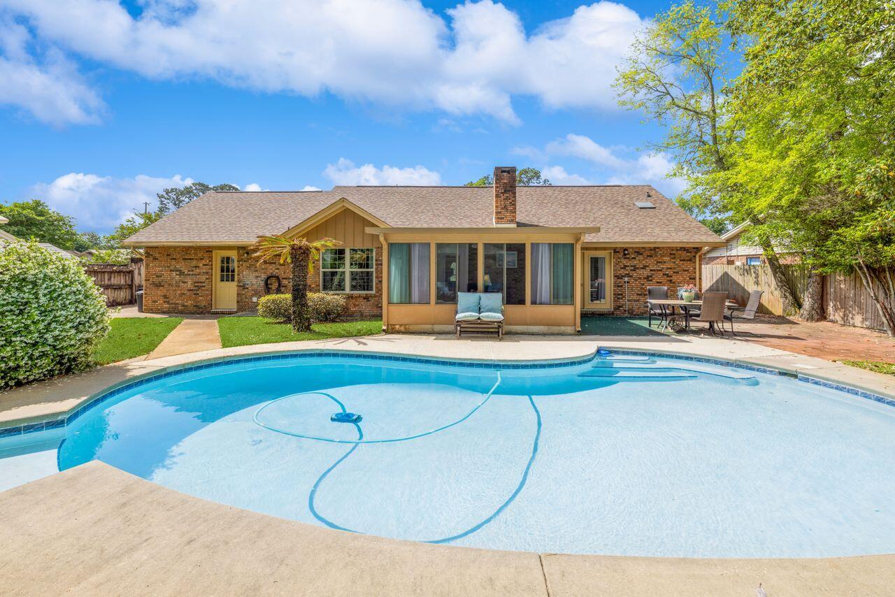 Welcome to the delightful Mary Esther Manor with NO HOA! This is a Beautifully maintained all-brick 3 bedroom/2 bath home in a great neighborhood with easy access from Mary Esther Cutoff (easy travel to Eglin AFB) and from US Highway 98 (easy travel to Hurlburt). Some perks of Mary Esther Manor are a lovely park, tennis courts, basketball courts, and side walks. The living space is open and inviting and includes the living room, kitchen and dining area. Features include crown molding, a wood-burning brick fireplace, and newer laminate flooring. The updated kitchen has gorgeous wood cabinetry with granite counters, a full stainless-steel appliance package (stove, microwave, dishwasher, refrigerator) and an island with sink, under-storage and an overlapping counter for barstools. Oh, and yes there is a pantry. There is a bonus room/office just off the foyer and the utility room, which has been previously expanded by the owner out from the kitchen/dining leading to the 2-car garage. There are two guest bedrooms and a full bathroom with tub/shower before you turn from the hallway into the primary bedroom suite. The bedroom is large and could even accommodate a reading nook. French doors from the bedroom lead to a private patio area. The master bath has a double-vanity, a undated tiled step-in shower, and a walk-in closet. Including the exterior door from the main bedroom, there are 3 doors that lead into the backyard. French doors from the living room first take you into the peaceful Florida room. Separated from the elements, you can spend many hours lounging in this area. The owner will be leaving a small electric fireplace for cool winter days. The third backdoor is located in the utility room, where the owner will also be leaving you a drink fridge and the washer and dryer.  Pool time!!! Newly resurfaced gunite pool is part of the backyard oasis at this home. Fruit trees and jasmine are only part of the landscaping, a shady gazebo has been added for pleasure and social gatherings. A small shed keeps all the equipment needed to take care of this paradise. By the way, the owner is going to leave you everything that you will need to maintain the yard:)  And that is not all! A 220-amp electric charging station is in the garage, tankless water heater, and a new roof and 8 new windows installed in 2022. Think about it, this is the JACKPOT!  So mark this one SOLD cause that is what it is going to be. OPEN HOUSE Sunday, April 27th from 10am to 4pm.