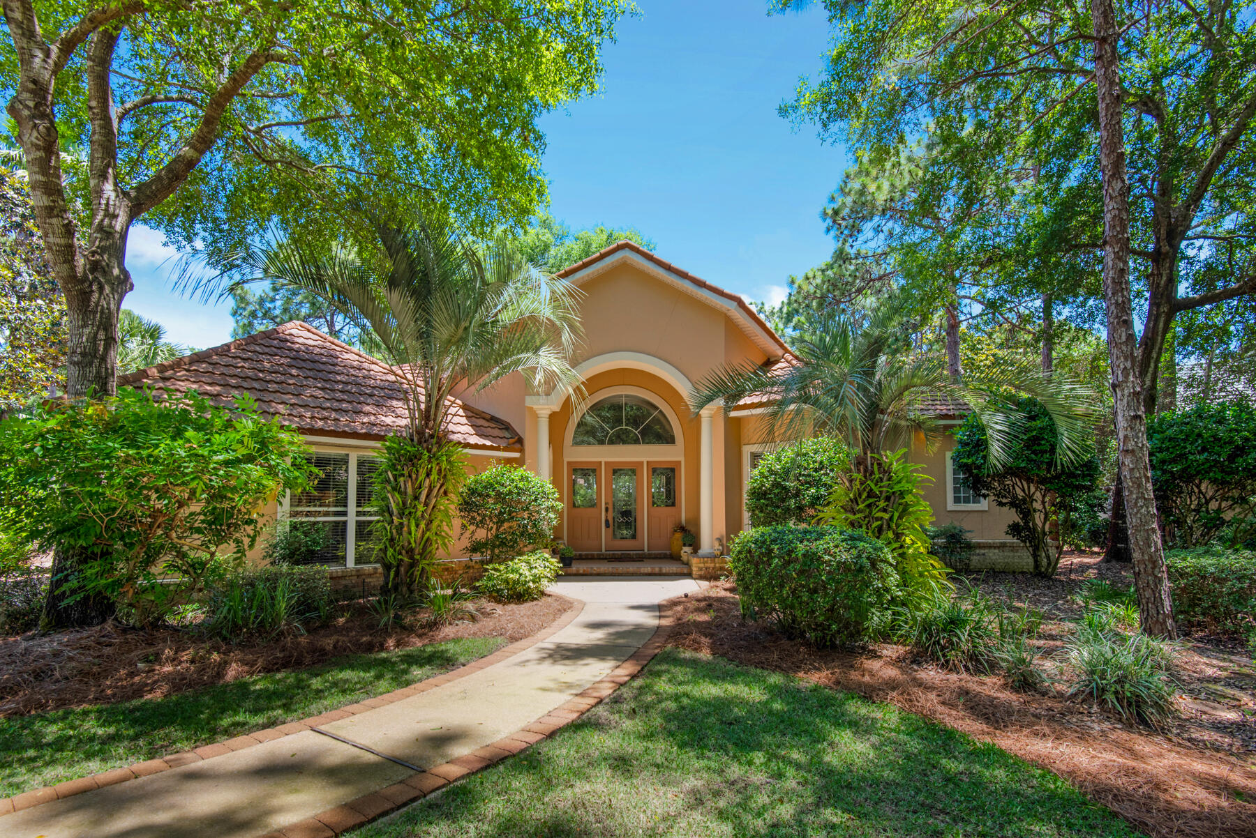 Voluminous spaces are highlighted by beautiful design in this stately home.  A unique, pillared foyer with archway opens to the grand living area. The vaulted great room has floor to ceiling windows that stun. Architectural elements enhance the wide spaces. The kitchen offers a center isle, substantial built-ins, pantry and wet bar. Clever, sleek cabinetry is found throughout the home. The master suite has a private corridor with a length of closets and dressing area that serves as a passageway to the office, or second bedroom and bath. The secondary wing has a long hallway with sculpture nook, third bedroom, full bath and large craft and laundry room.  Sited with nature in mind, every window beckons with a park-like view. There are two newer air conditioners and a stone coated metal roof.