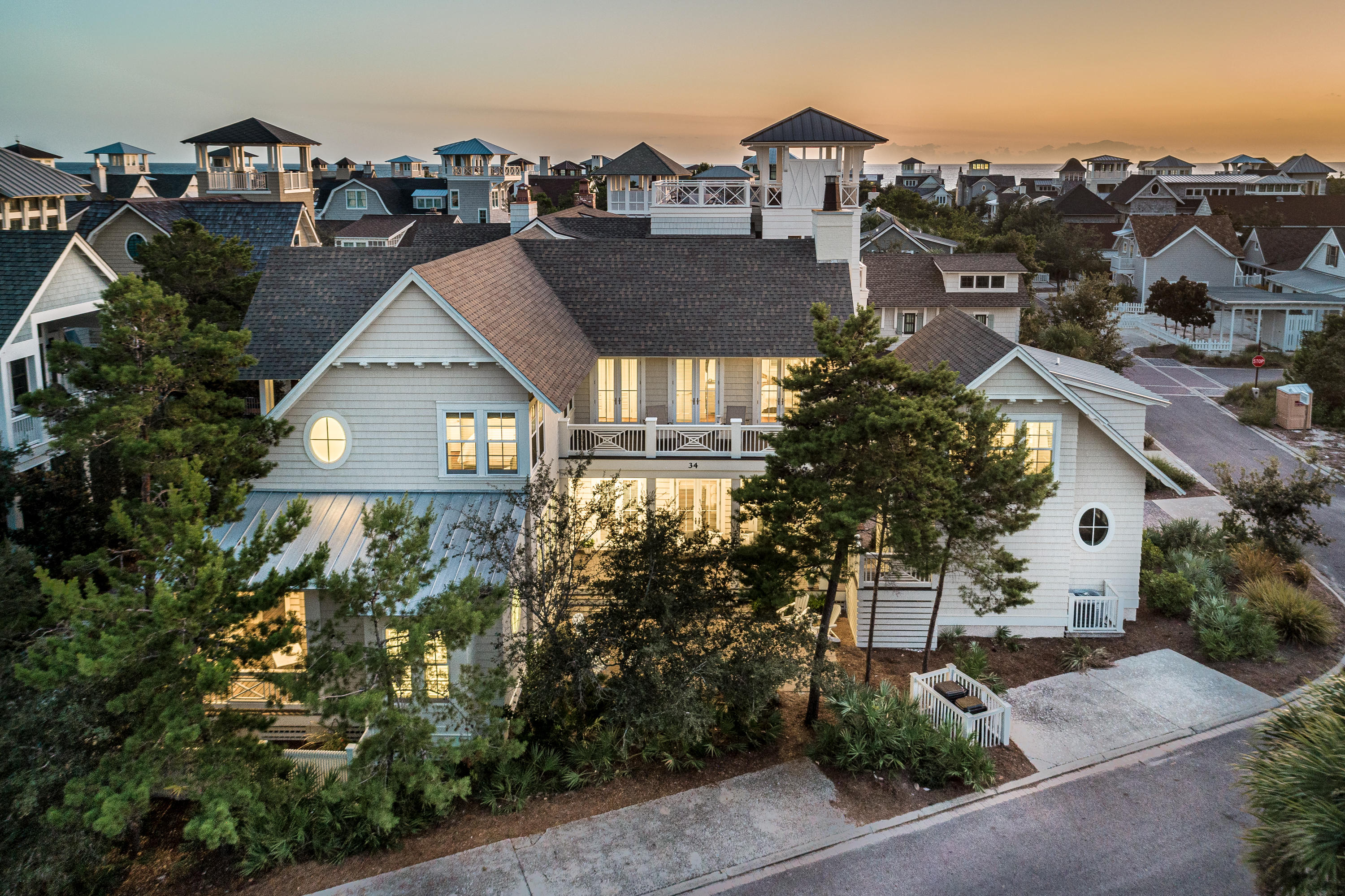 This incredible Watersound Beach home offers 3,499 sf of beautifully designed living space including 4 bedrooms, 4.5 baths in the main house, 2 living rooms. The home's carriage house sits atop it's 1.5 car garage and includes another bedroom, full bath and wet bar! Upon entering the home you will notice the 12 ft ceilings, and eye-catching hand-scraped oak flooring. The kitchen is finished with Thermador appliances and marble countertops, and the home's fireplace, coffered ceilings and shiplap accents add texture and warmth to the main living area. Also found on the main level are a powder room, laundry facilities, and the first of 2 master suites. This master's ensuite bath has a stately oval window separating the 2 vanities, and marble covers every surface. The second level of the home
