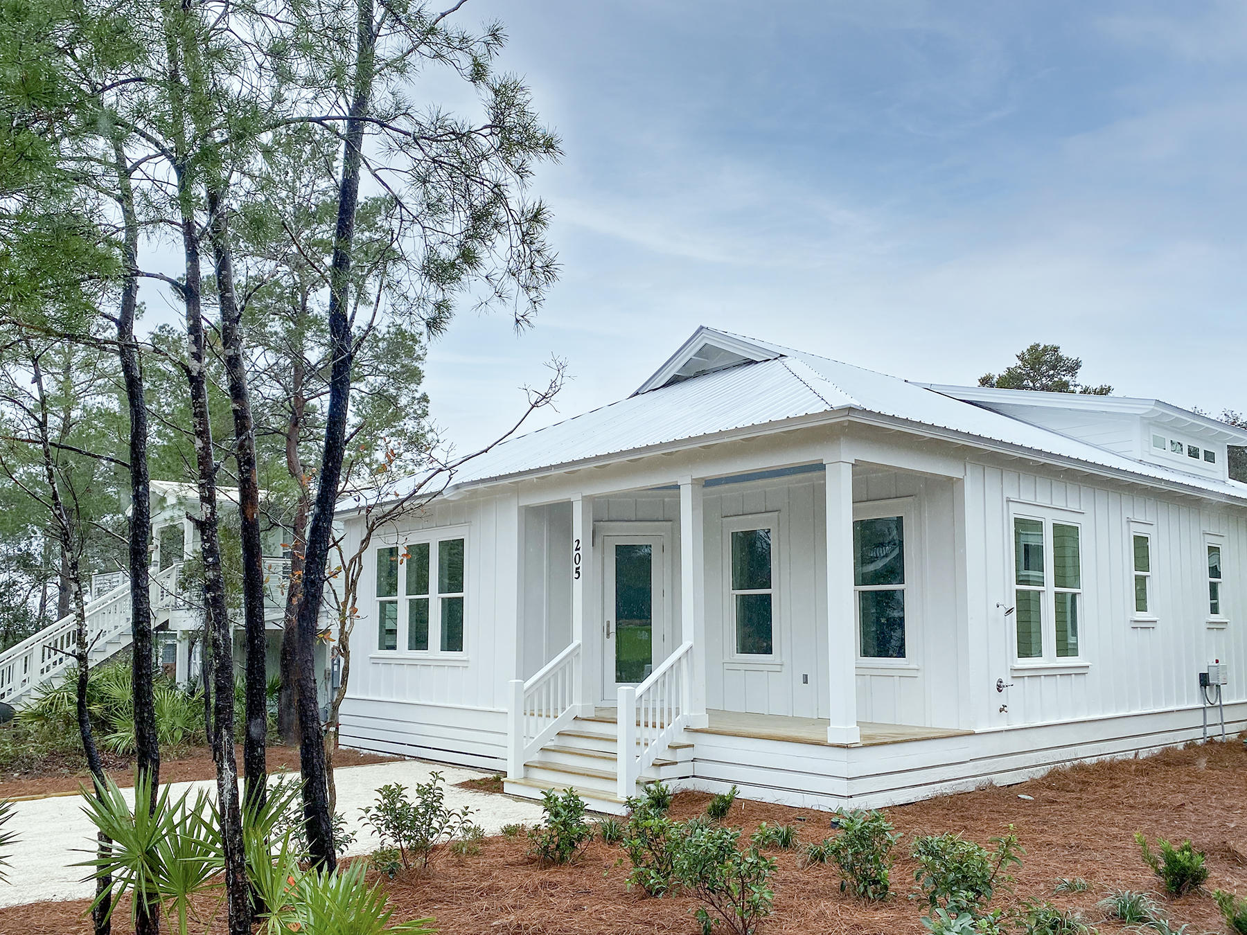 Be the first to own this charming 2020 modern built home on the desirable south side of 30A! A short stroll down your street to Eastern Lake & a Beach access that opens up to the beautiful white sands and emerald green waters of the Gulf of Mexico. This home could be your new forever home or a rental being so close to beach and in the heart of 30A. The exterior of the home's hardy plank painted white with a metal roof together this one story beach house is a beauty. The open front porch is inviting and relaxing which makes a great first impression. The front door opens into your living and dining room, 12 foot ceilings and large windows allows for sun light in these spaces. The dining room has a large walk through butler's pantry, its pocket doors open for a easy kitchen access.