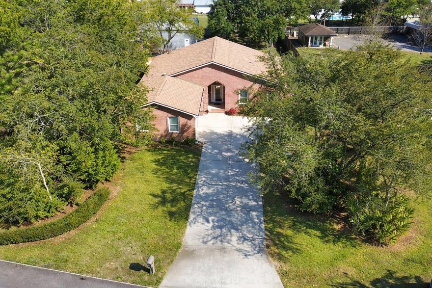 All-brick corner lot home in the heart of Navarre! This 4-bedroom, 3-bath home sits on a spacious .46-acre lot just minutes from Navarre Beach. Featuring a desirable open/split floor plan with two large primary suites, this home offers both comfort and flexibility. Raised ceilings create an open, airy feel--perfect for entertaining or accommodating a large family. The kitchen is equipped with new appliances, granite countertops, and a large island, providing ample prep and gathering space. Enjoy the convenience of an indoor laundry room with washer and dryer included, plus additional living space in the Florida room. The primary bath features a jetted tub and oversized shower combo. Outside, you'll find a newly built 28x30 shop with a 17' roof pitch, offering easy access from Granada St.