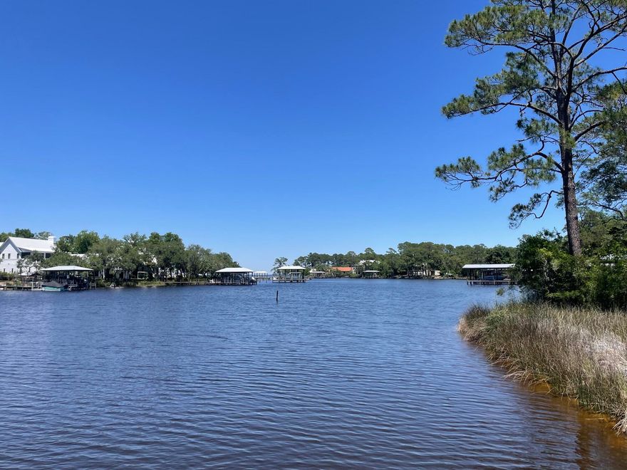 Waterfront 3BR/2BA cottage with stunning bayou views from almost every room. Screened-porch swing overlooks mature oaks and water. Primary suite features bay views, private sundeck, two walk-in closets, and separate vanity. Large kitchen w/ island opens to family room. Two screened porches, charming window seat in guest bedroom, and Mexican tile and carpet throughout. Includes boat dock & boathouse w/ lift. New roof 6/2025. New Carpet 5/26.Survey available. Unique Florida cottage you won't want to leave!