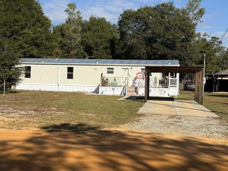 2BR/1BA manufactured home on an oversized 0.46-acre homesite in DeFuniak Springs, comprised of two 0.23-acre lots. Built in 2006 with an efficient 864 SF layout and over $45K in upgrades completed in 2024, including commercial-grade LVP flooring, a mini-split system, deck, galvanized metal roof, gutters, and a new septic system.

Outside features include a carport with additional covered parking, multiple sheds, and a workshop with power, ideal for projects or extra storage. The second 0.23-acre lot includes a septic tank and existing public water and electric hookups already in place, making it perfect for RV parking, future use, or potential resale. Seller will remove the shipping containers at buyer's request. *Information is believed to be accurate. Buyer to verify all information.