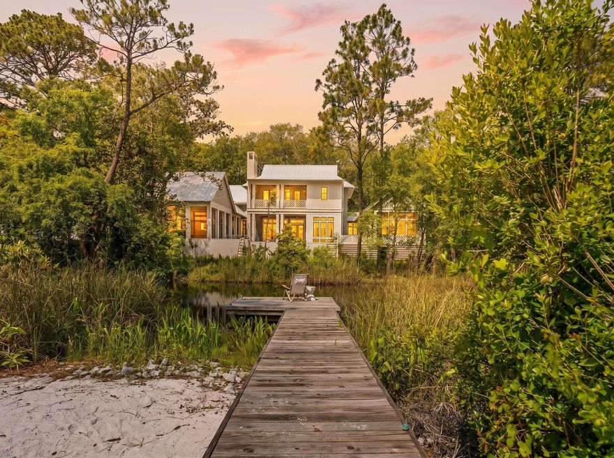 Tucked into the lush, canopied heart of Grayton Beach, this stunning 30A cottage offers a rare combination of dune lake frontage, beautifully curated interiors, and effortless coastal living. Set on over a fifth of an acre with 63 feet of lake frontage and a private boardwalk, 353 Wilderness Way is a true sanctuary.

Inside, vaulted ceilings with exposed wood beams soar above an open living space anchored by a dramatic floor-to-ceiling terrazzo fireplace with a live-edge mantel. French doors, a shell-and-crystal chandelier, and rich hardwood floors throughout complete the picture. The chef's kitchen impresses with white cabinetry, quartz countertops, a mosaic tile backsplash, gas range, and a large island. Three bedrooms offer peaceful retreats, and the thoughtfully finished bathrooms include a charming powder room with a teal vanity and antique gilt mirror. Multiple decks, a screened porch, and a spiral staircase connecting levels make outdoor living just as inviting as in -- with the dune lake steps away for kayaking, paddleboarding, or simply unwinding at the water's edge.

Steps from the beaches, dining, and boutiques that make Grayton Beach a perennial 30A favorite. Dune lake frontage like this is exceptionally rare - don't miss it.