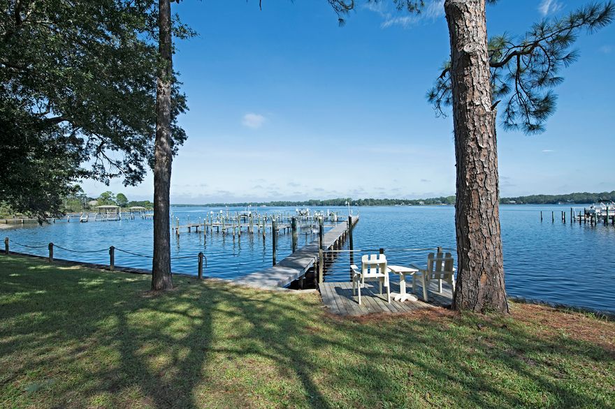 Low Maintenance Waterfront Living w/your own deeded Boat Slip on East Bay! If you are looking for spectacular sunsets that let you unwind, relax, & watch dolphins play you found it. Nice community w/pool & located right across the street from prestigious Hidden Creek Golf Course. Beautifully updated 3 bedroom & 2 1/2 baths. New driveway, tiled walkway to the front door, tiled storage area between the garage and the townhome. New granite counter tops, stainless steel appliances and a wine fridge. Tile floors downstairs and carpet upstairs and in the bedrooms. Updated lighting. Seller installed a new power chair to go up and down the stairs but that can be removed if not needed. Screened in porch to sit out and enjoy the beautiful sunsets, and mature trees line the back of this property