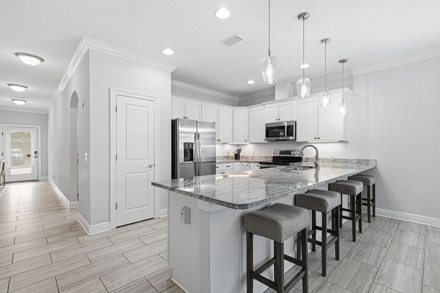 Presenting 91 Bayside Park: a beautifully maintained, custom-built home completed in 2017 and offering the feel of near-new construction. This move-in ready property is perfectly positioned directly across from the community park, featuring a resort-style pool, tennis and pickleball courts, playground, pavilion, expansive green space, and a 100-foot dock extending into the bay for residents to enjoy.  Since completion, the owner has invested approximately 90k in upgrades, including epoxy flooring in the garage, plantation shutters throughout, a full gutter system, covered rear patio, brick paver enhancements, and upgraded attic insulation for improved energy efficiency, plus additional thoughtful improvements. This turnkey home offers both comfort and convenience in an unbeatable location.